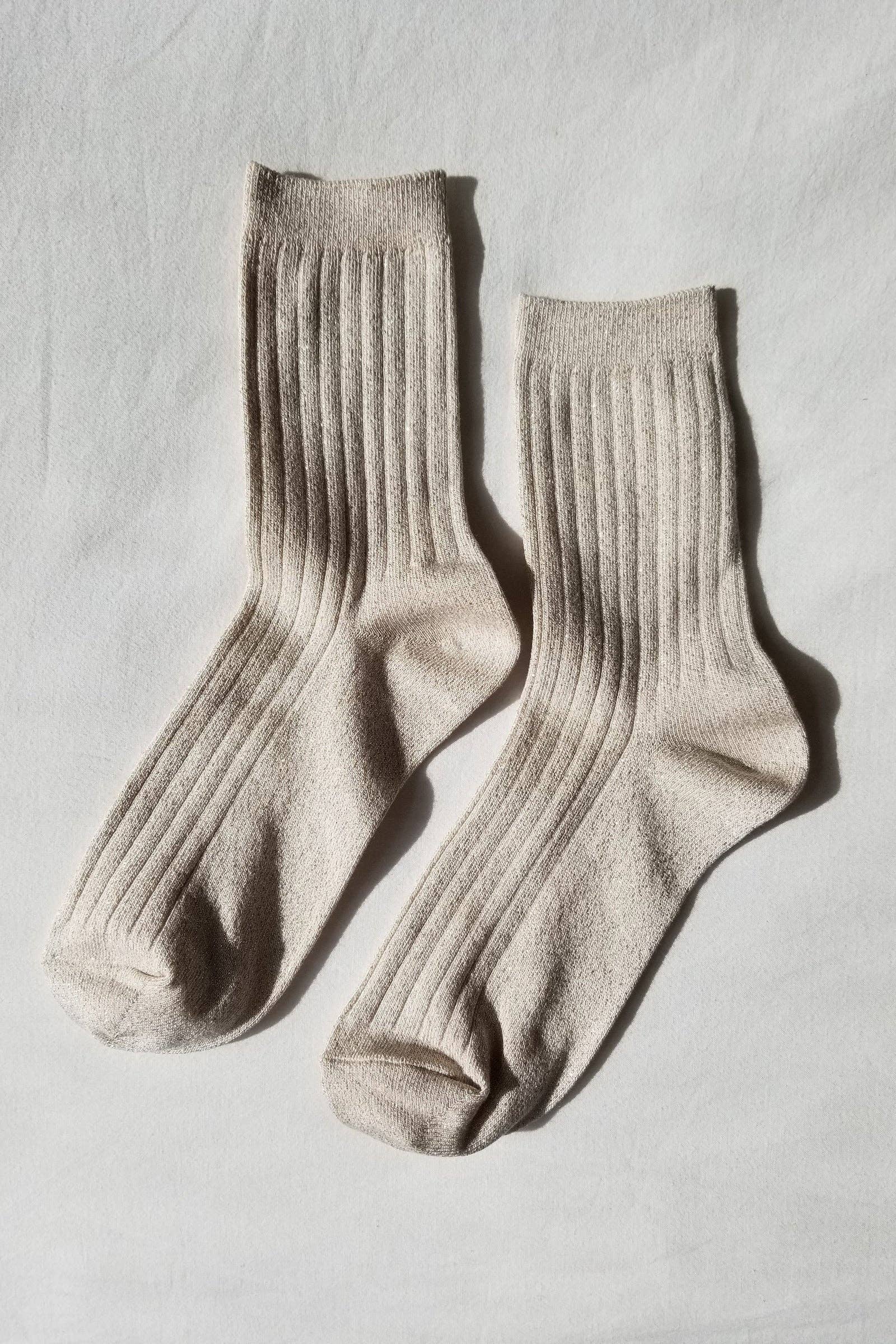 A pair of women's Le Bon Shoppe Spring fashion ribbed crew socks in ivory gold color with sparkles throughout at Alas Eius