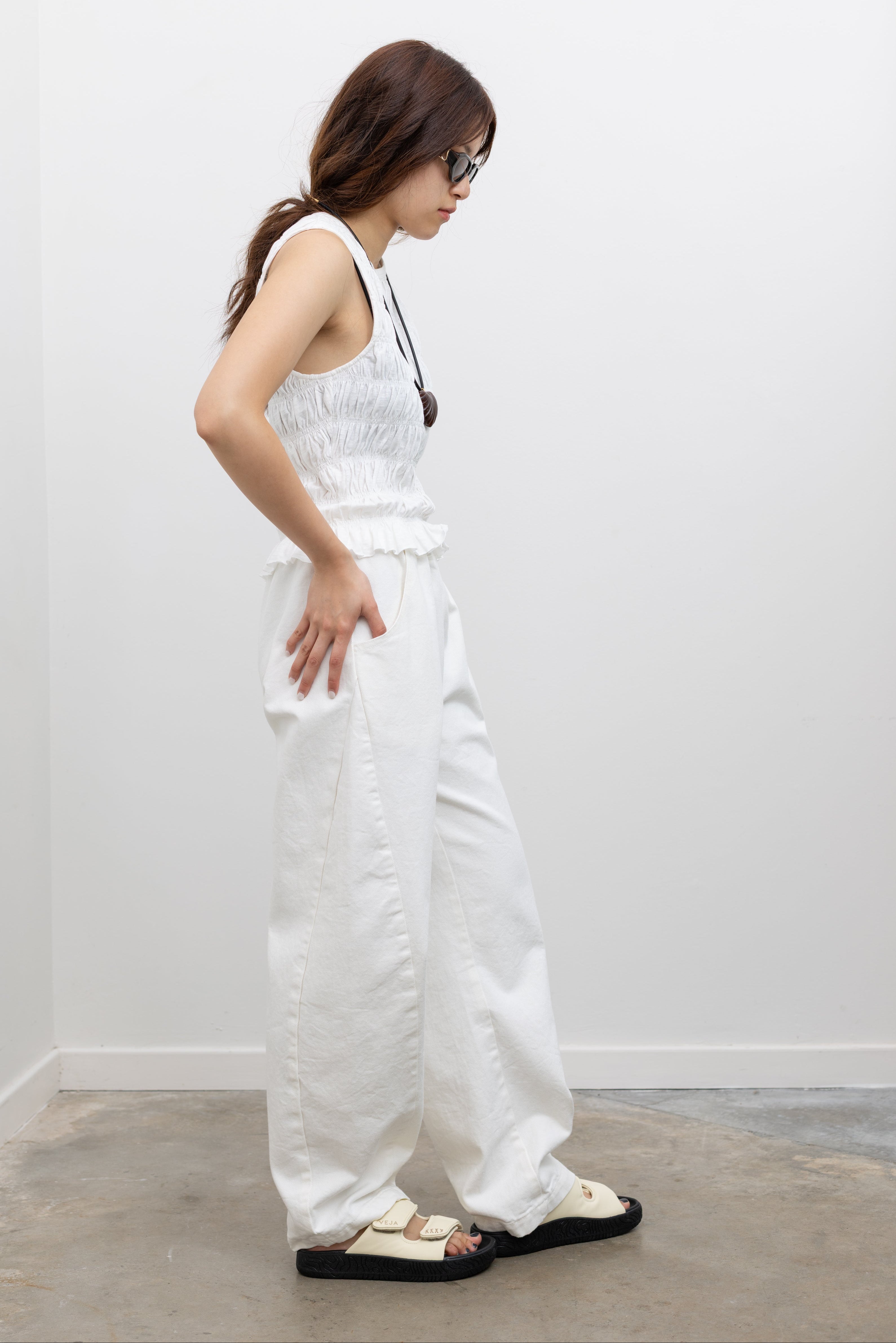Le Bon Shoppe minimalist milk white cotton pants with curved silhouette and side panel design, finished with deep pockets and elastic waistband, styled as women’s street style fashion trousers at Alas Eius