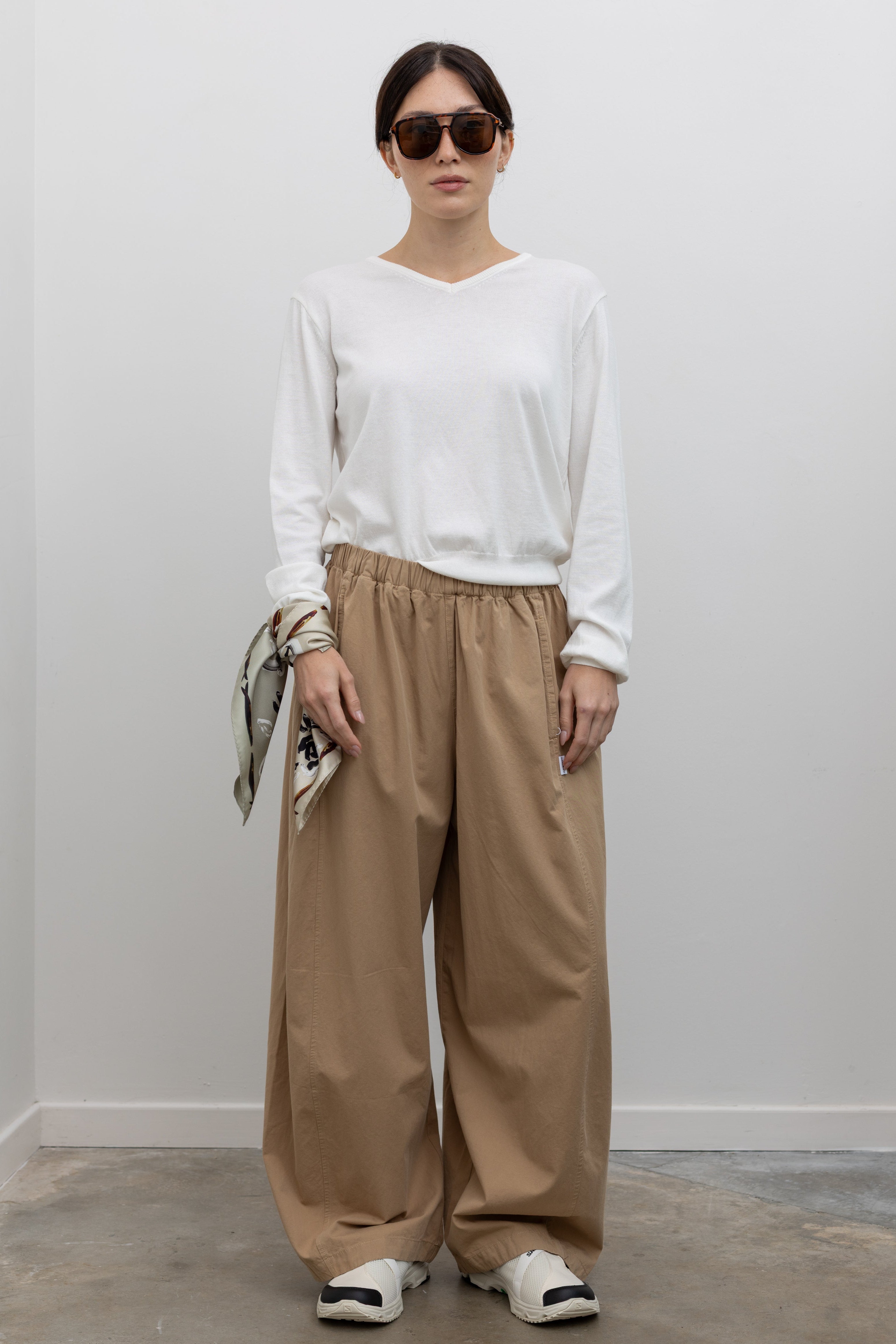 Full length front view of a woman wearing an elevated classic in the Le Bon Shoppe Khaki Cotton Parachute Pants featuring a lightweight cotton fabric, elastic waistband, and voluminos oversized leg shape at an Alas Eius store.