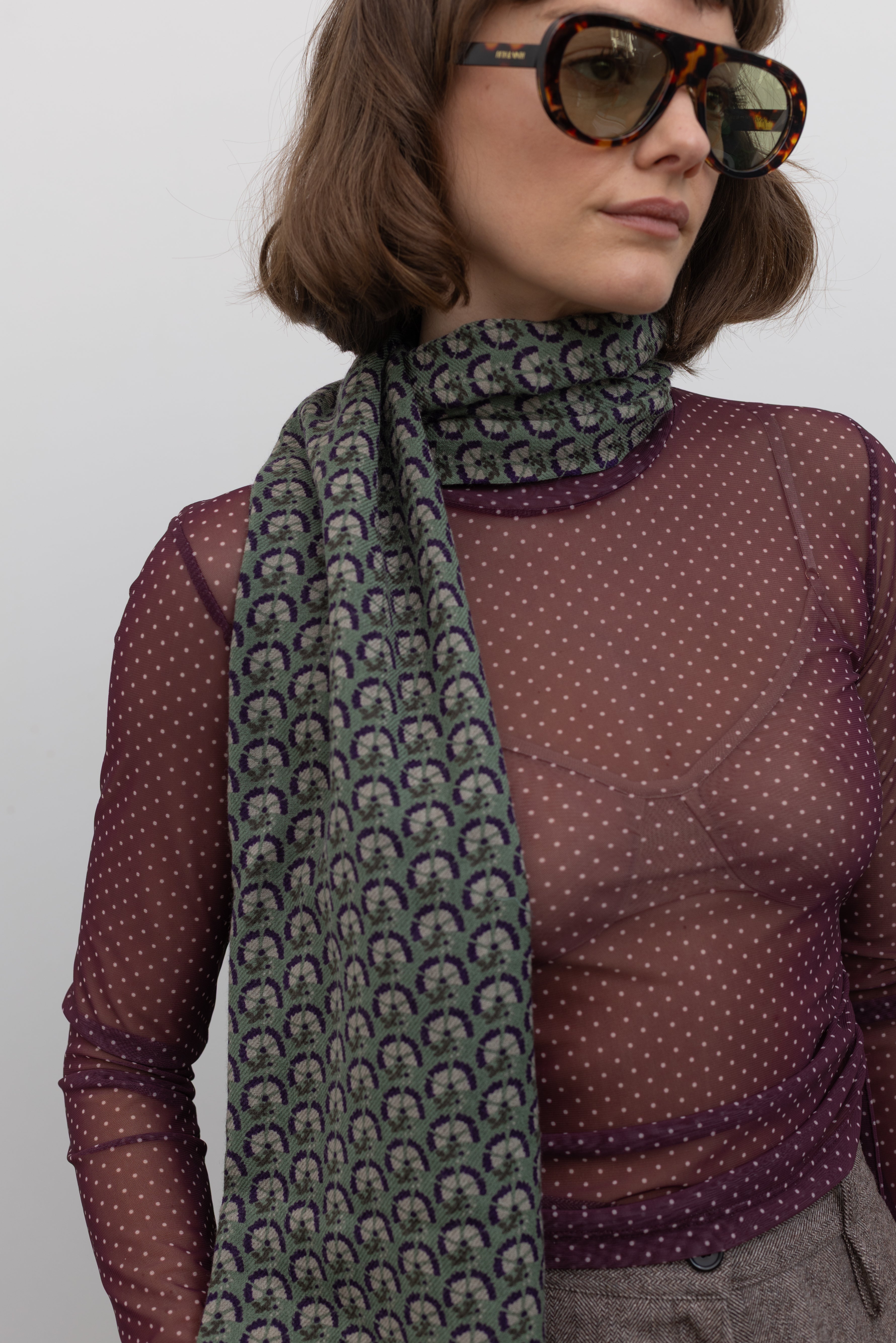 Woman wearing fall/winter accessory in a Les Belles Vagabondes brand Marigold green wool printed scarf at Alas Eius