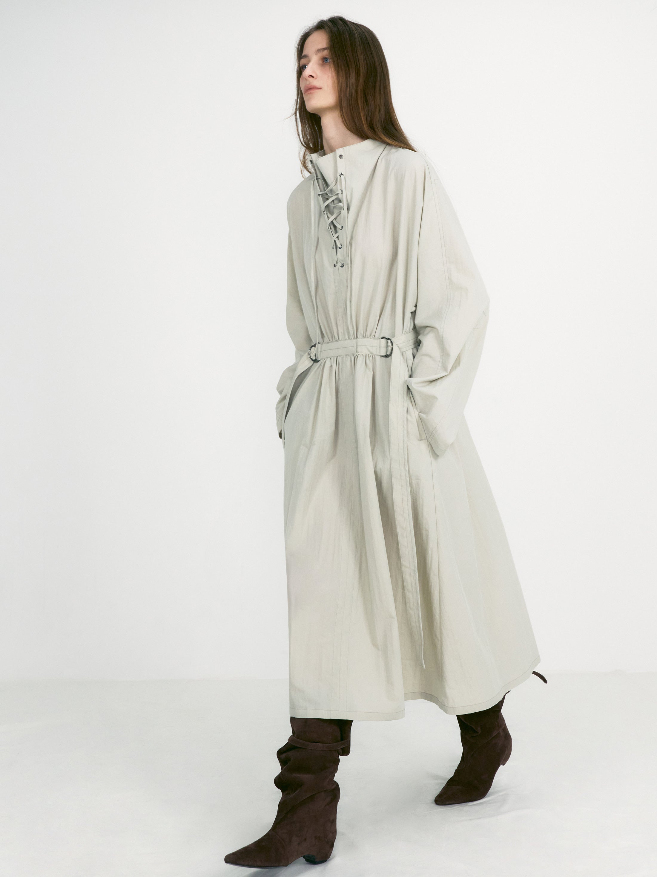 Woman in motion wearing the chic and versatile Low Classic Brand Brown Suede Middle Boots featuring a slouchy leg and a strap and buckle detail at the top at Alas Eius.  