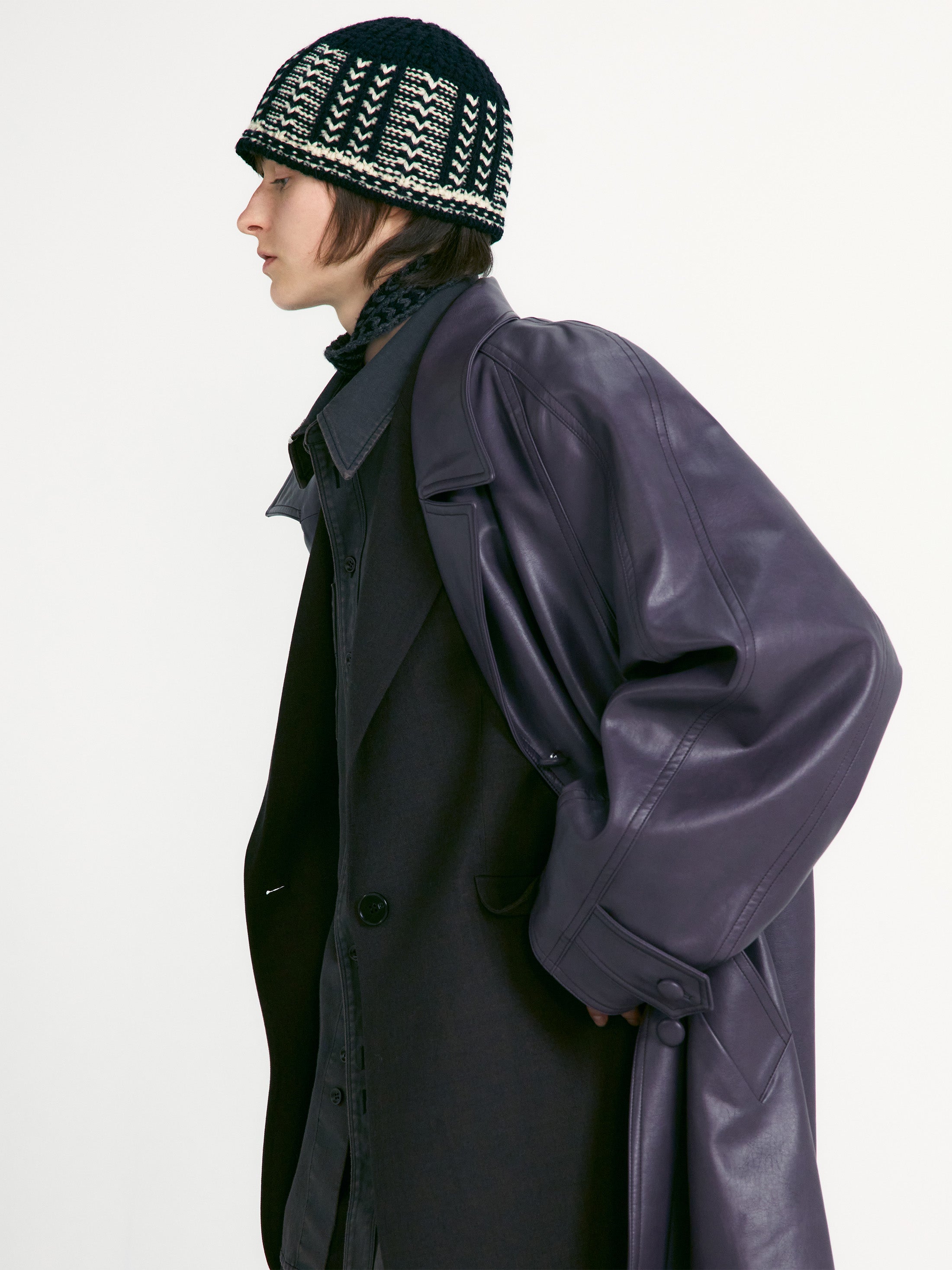 Side view of a woman wearing winter fashion accessory in a Low Classic Black And White Jacquard Knit Beanie at Alas Eius. 