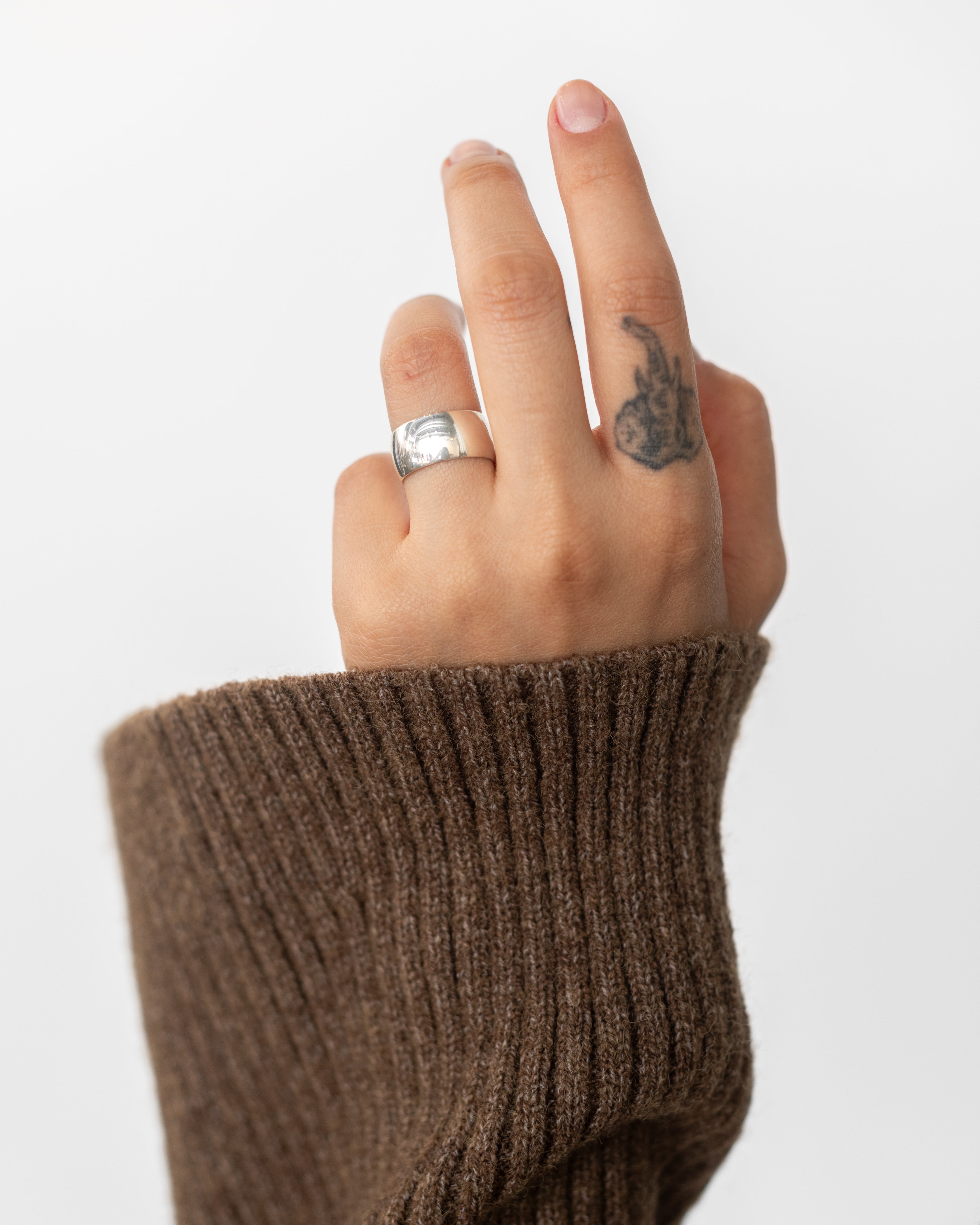 Woman wearing contemporary jewelry in a masculine yet feminine Maslo Sterling Silver Cigar band ring at Alas Eius. 