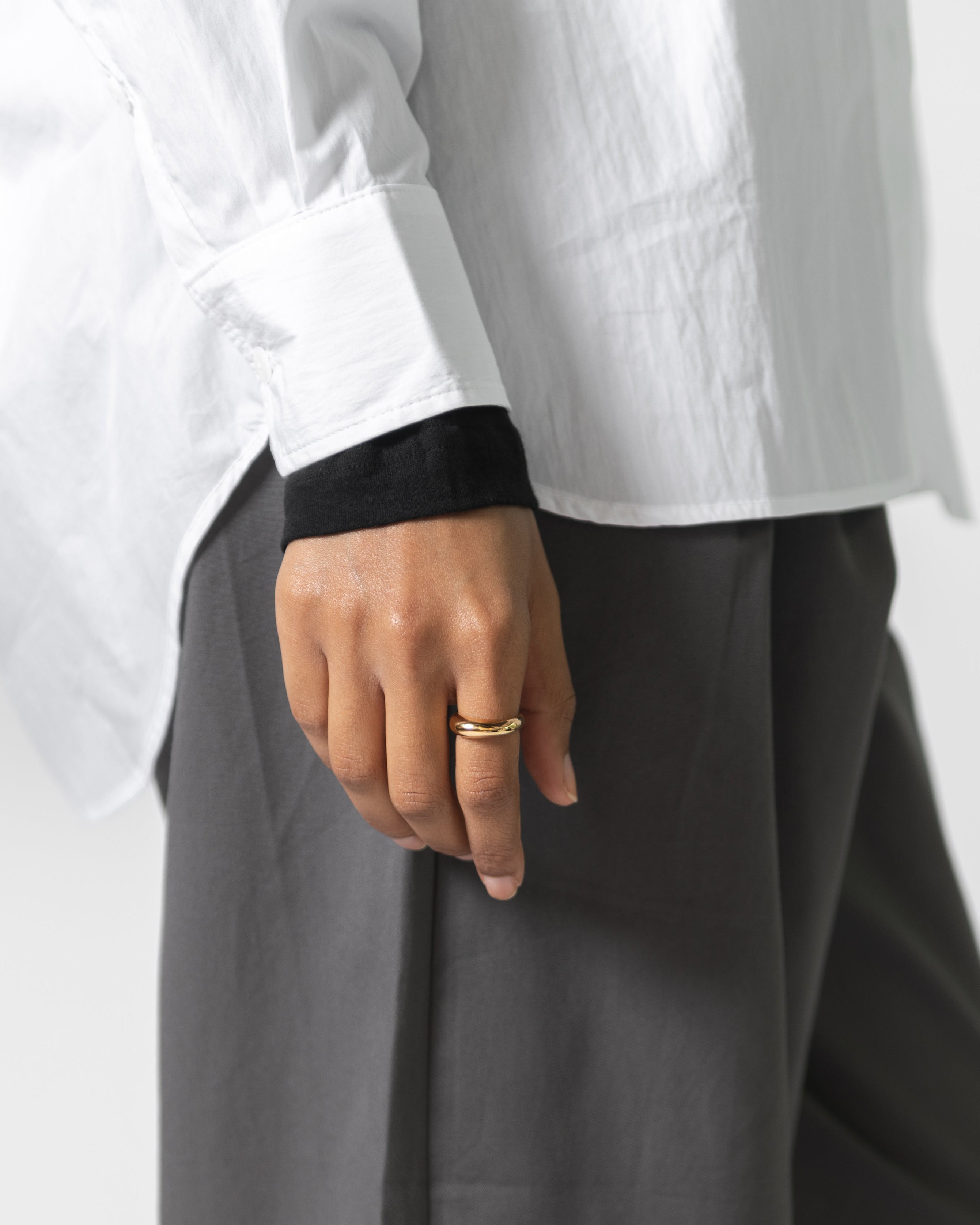 Woman wearing minimalist contemporary jewelry in a Maslo 14k gold plated dome ring at Alas Eius. 