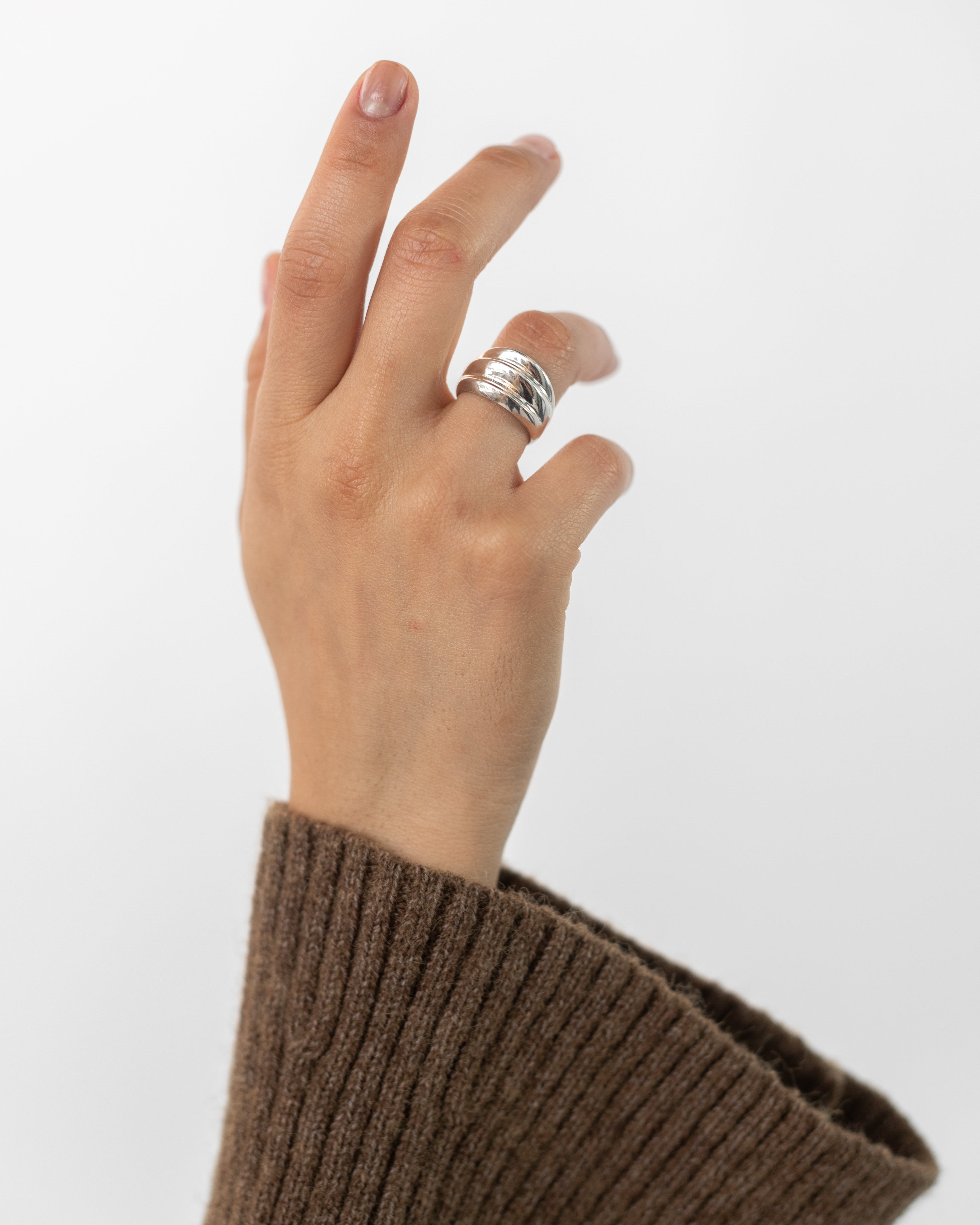 Woman wearing contemporary jewelry in a Maslo triple sterling silver ring at Alas Eius. 