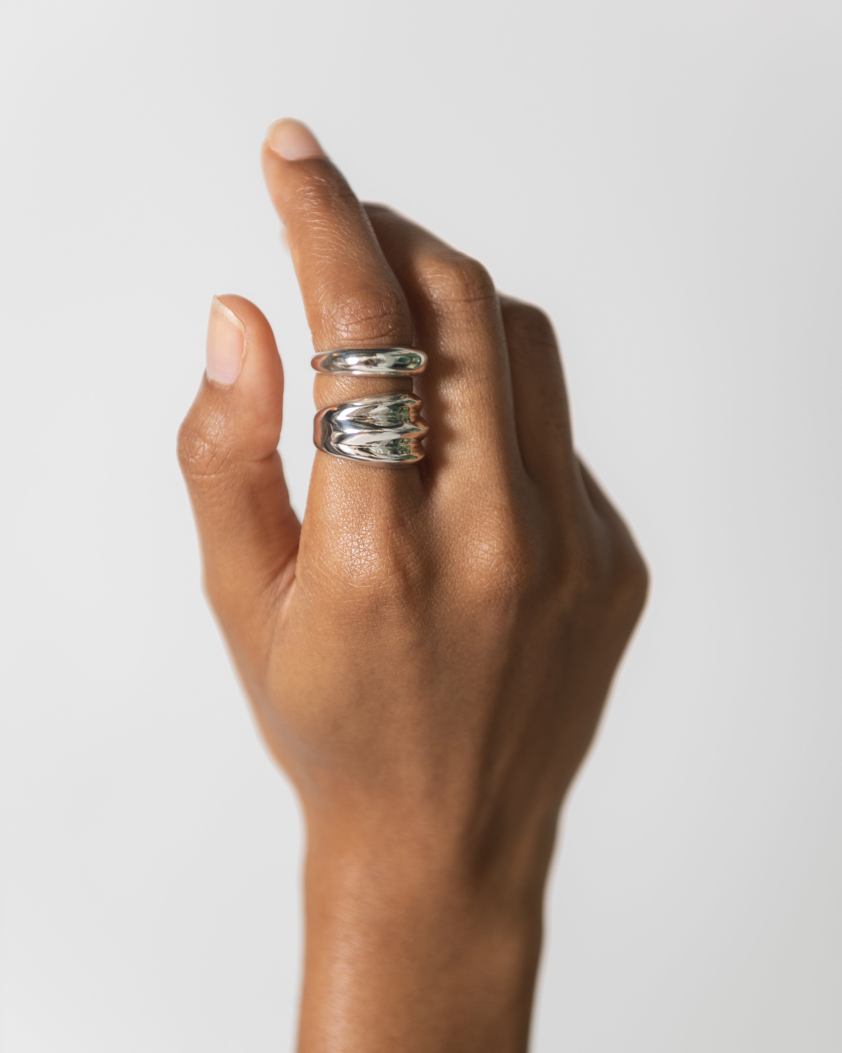 Woman wearing contemporary jewelry in a Maslo triple sterling silver ring at Alas Eius. 