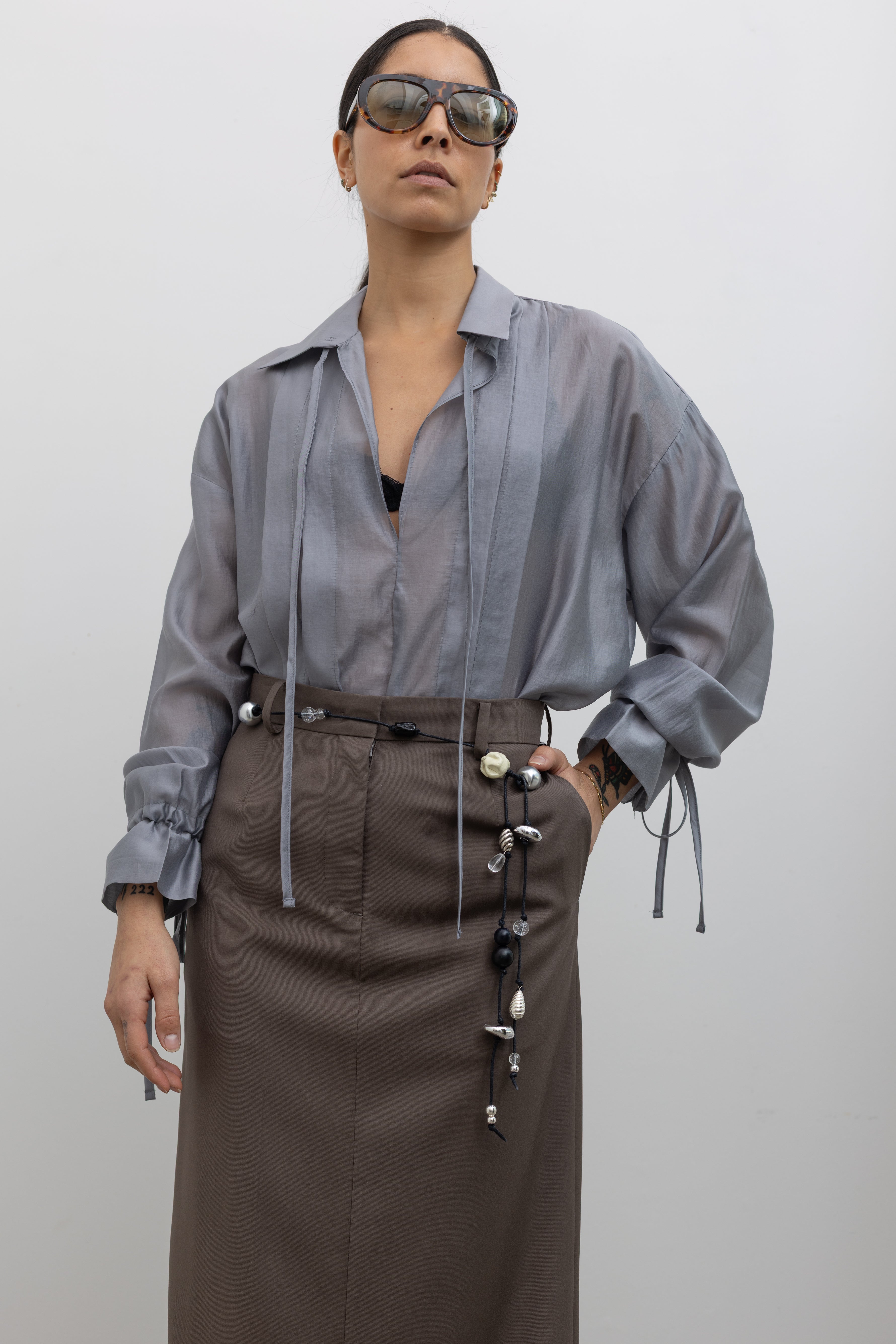 Woman wearing one-of-a-kind Maslo belt made with vintage beads strung on a black woven cord at Alas Eius.