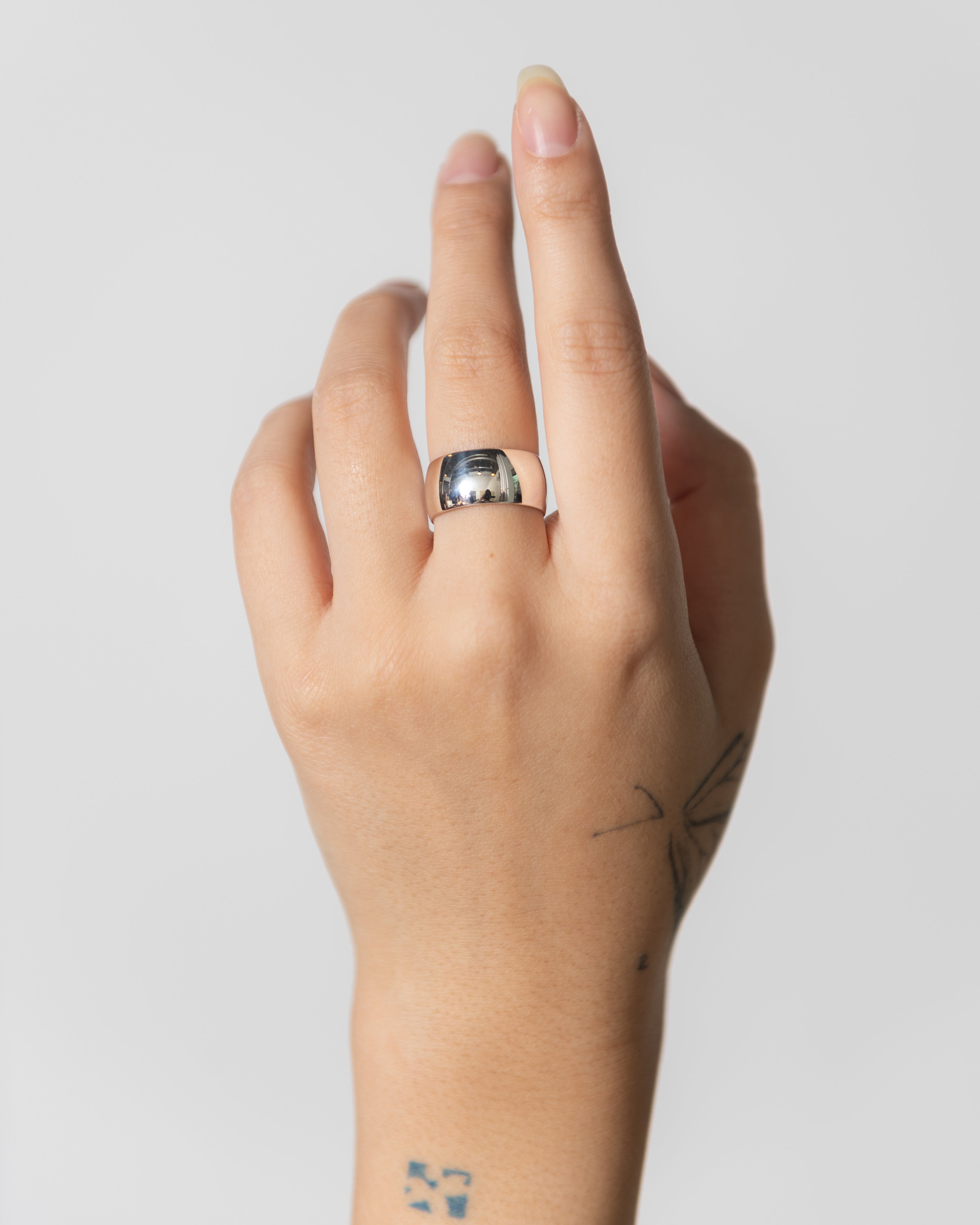 Woman wearing contemporary jewelry in a masculine yet feminine Maslo Sterling Silver Cigar band ring at Alas Eius. 