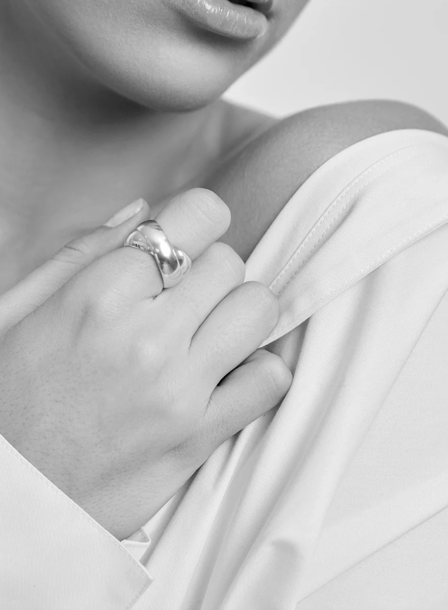 Woman wearing a contemporary minimalist Maslo linked sterling silver ring at Alas Eius. 