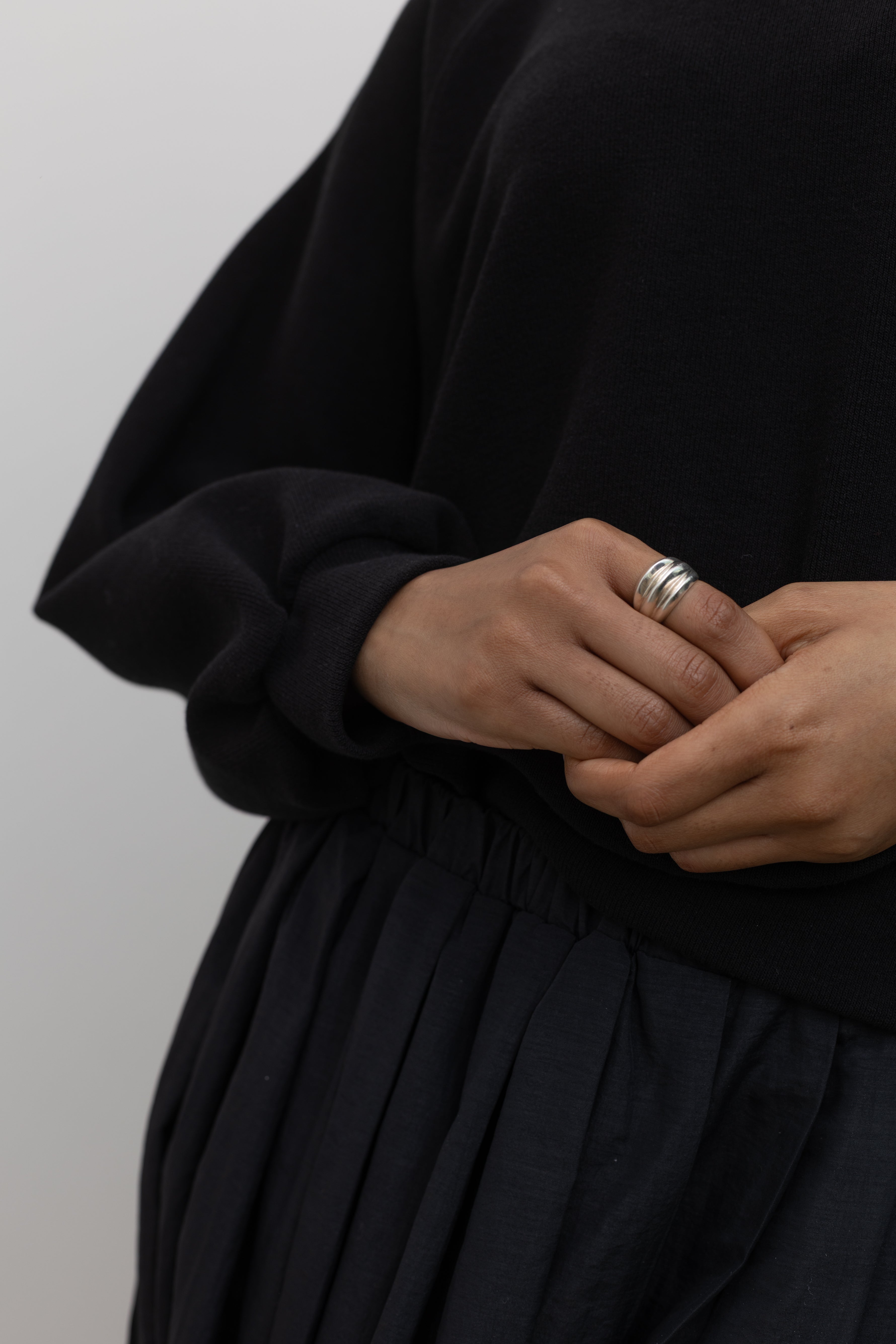 Woman wearing contemporary jewelry in a Maslo triple sterling silver ring at Alas Eius. 