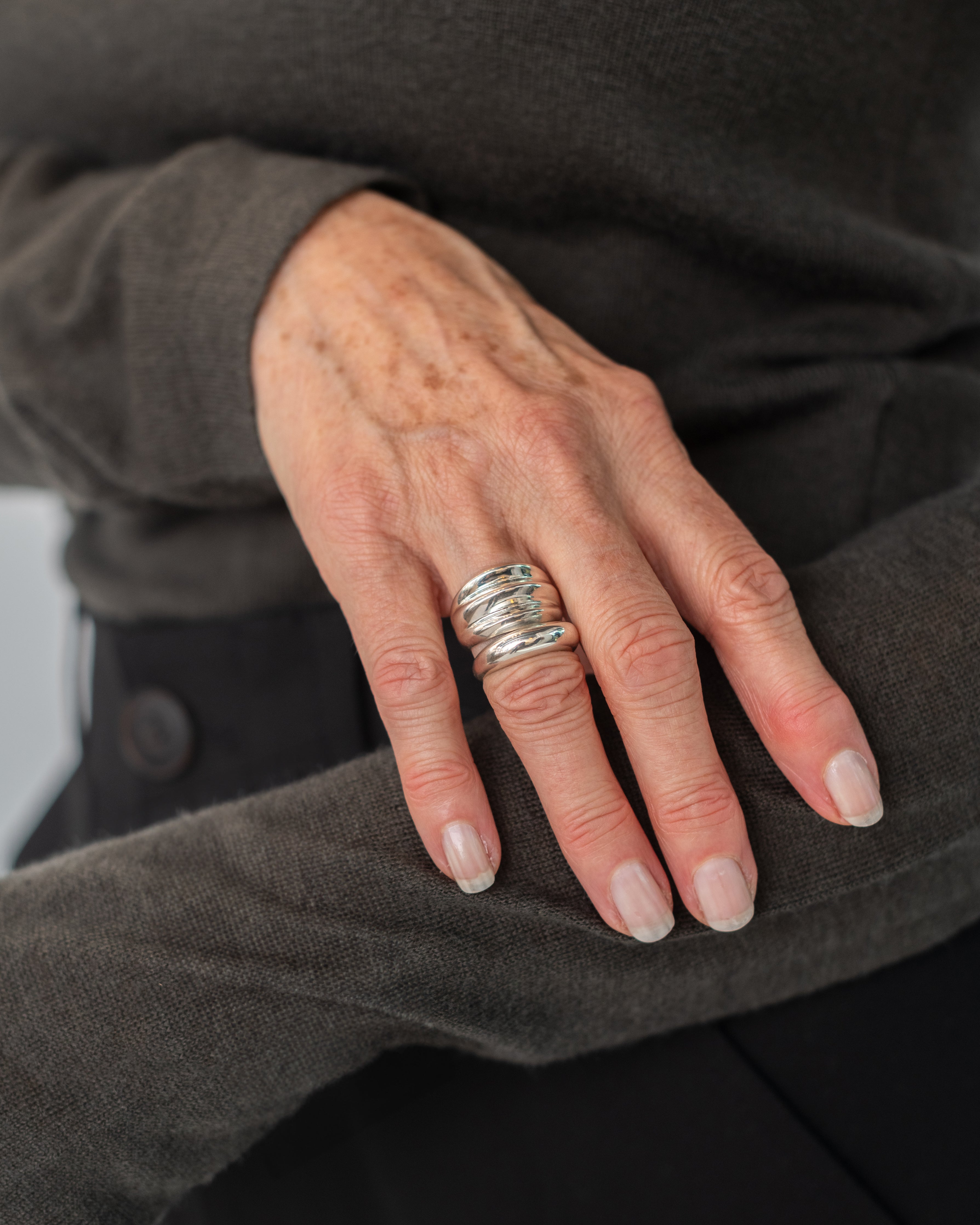 Woman wearing contemporary jewelry in a Maslo triple sterling silver ring at Alas Eius. 