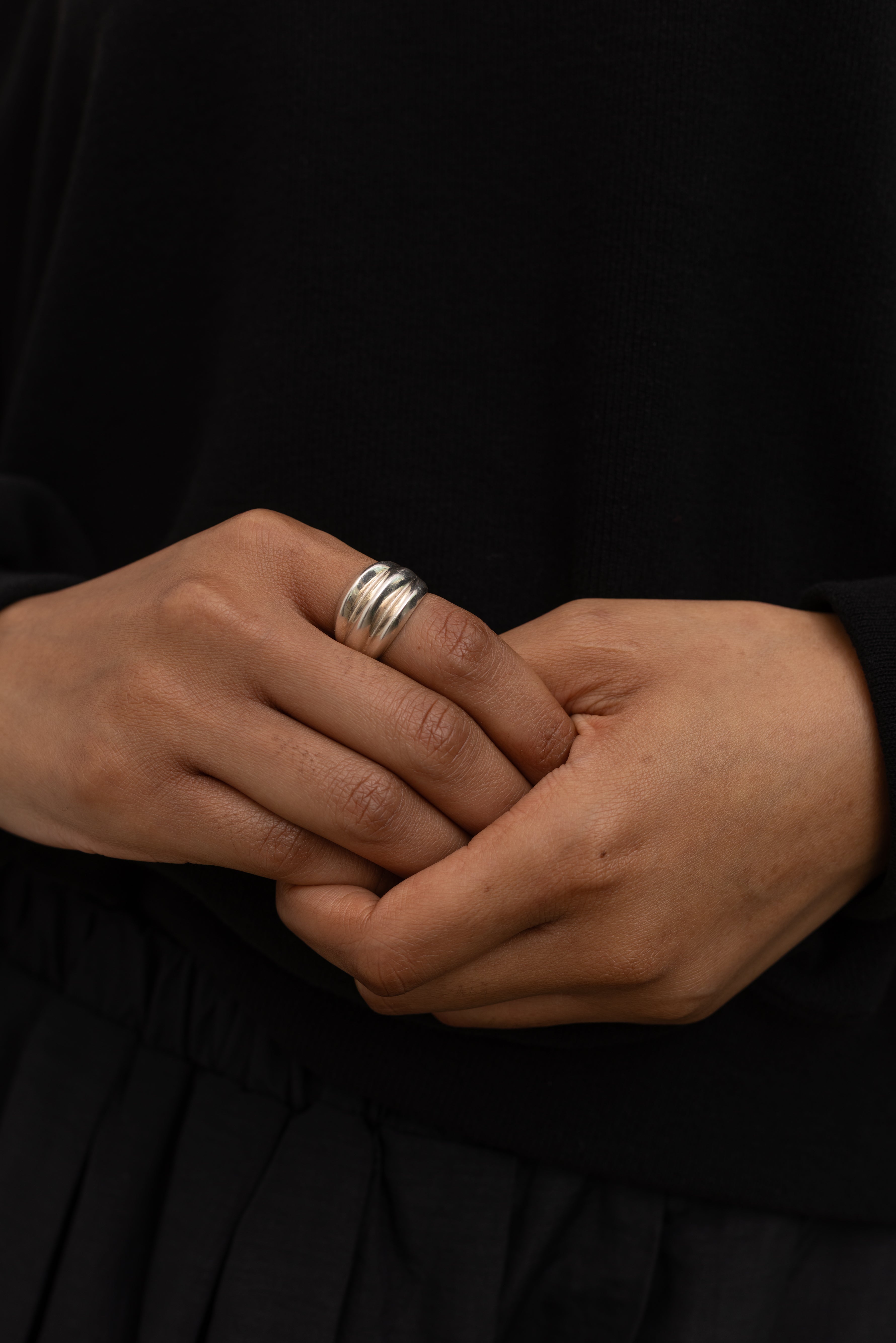 Woman wearing contemporary jewelry in a Maslo triple sterling silver ring at Alas Eius. 
