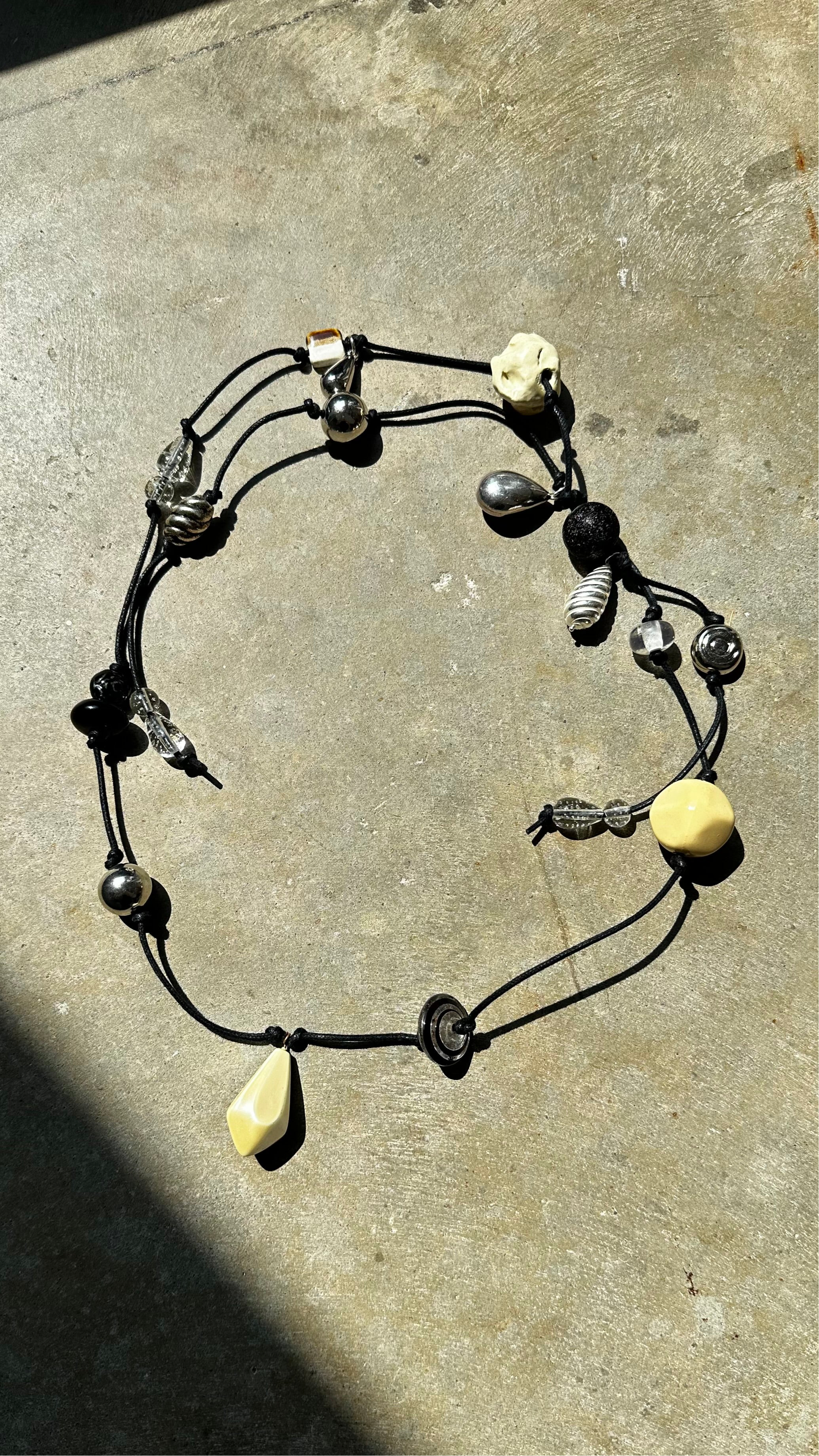 Close-up view of one-of-a-kind Maslo belt made with vintage beads strung on a black woven cord at Alas Eius.