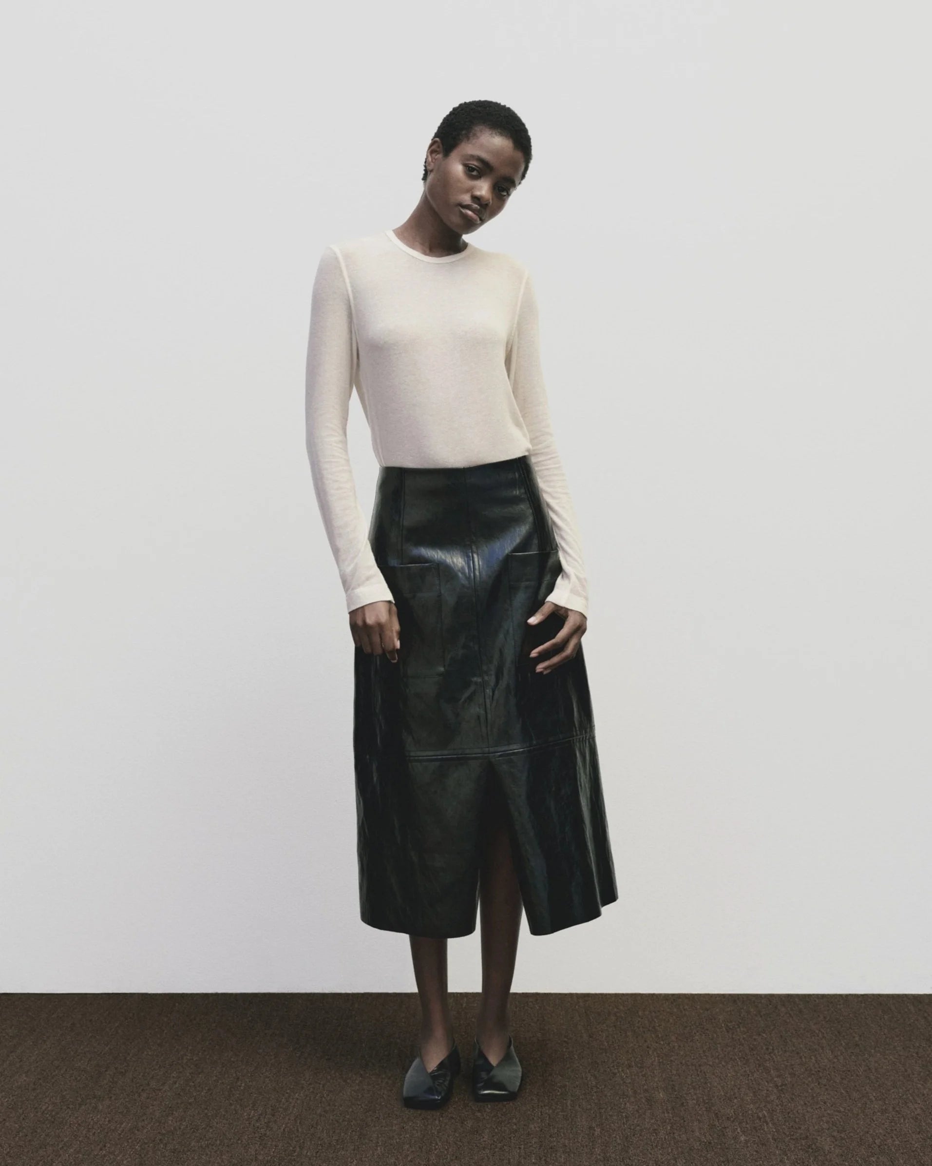 Back view of woman standing wearing a Mijeong Park Ivory Wool Tencel Crewneck Top at Alas Eius