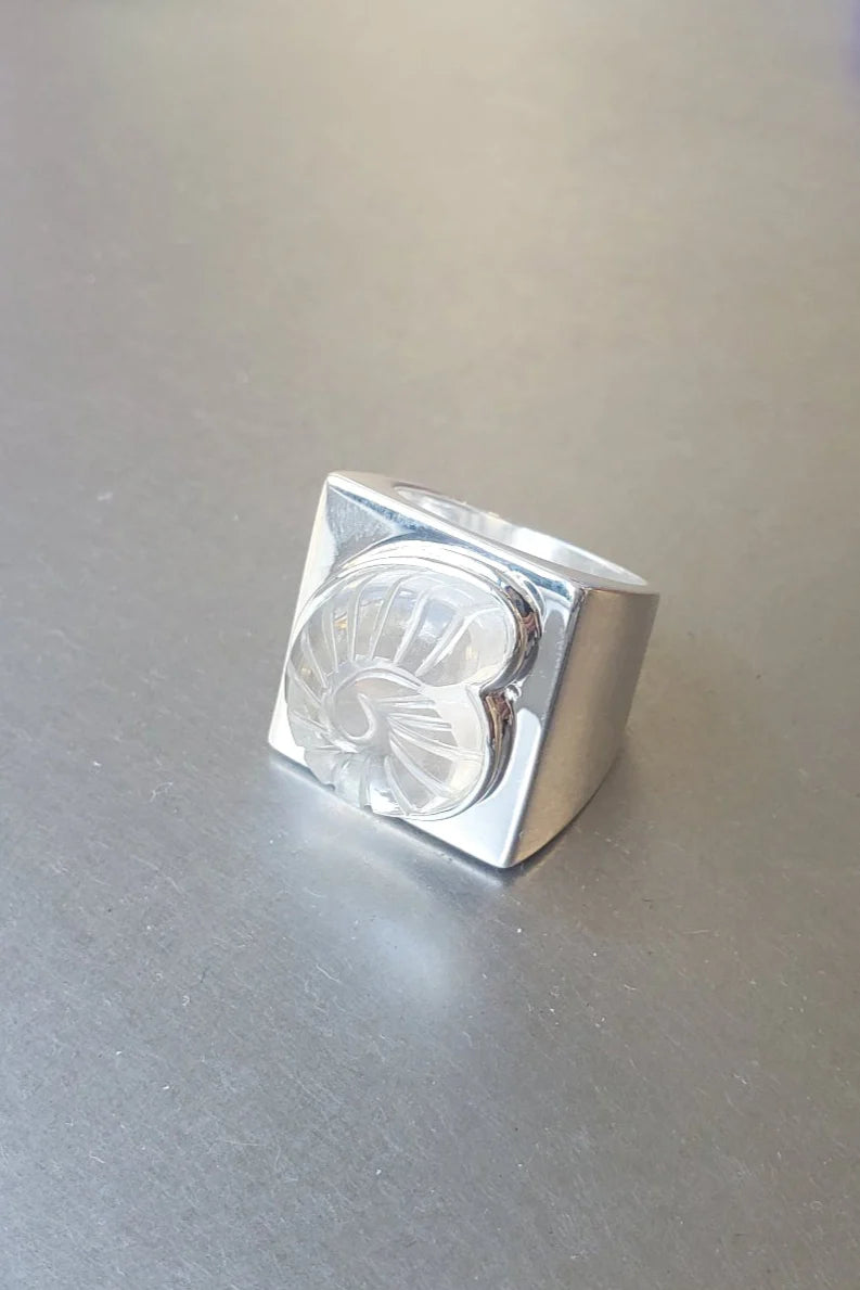 Contemporary design in a Nomia statement ring crafted in high polished solid sterling silver with a clear hand carved Nautilus Stone design at an Alas Eius store.
