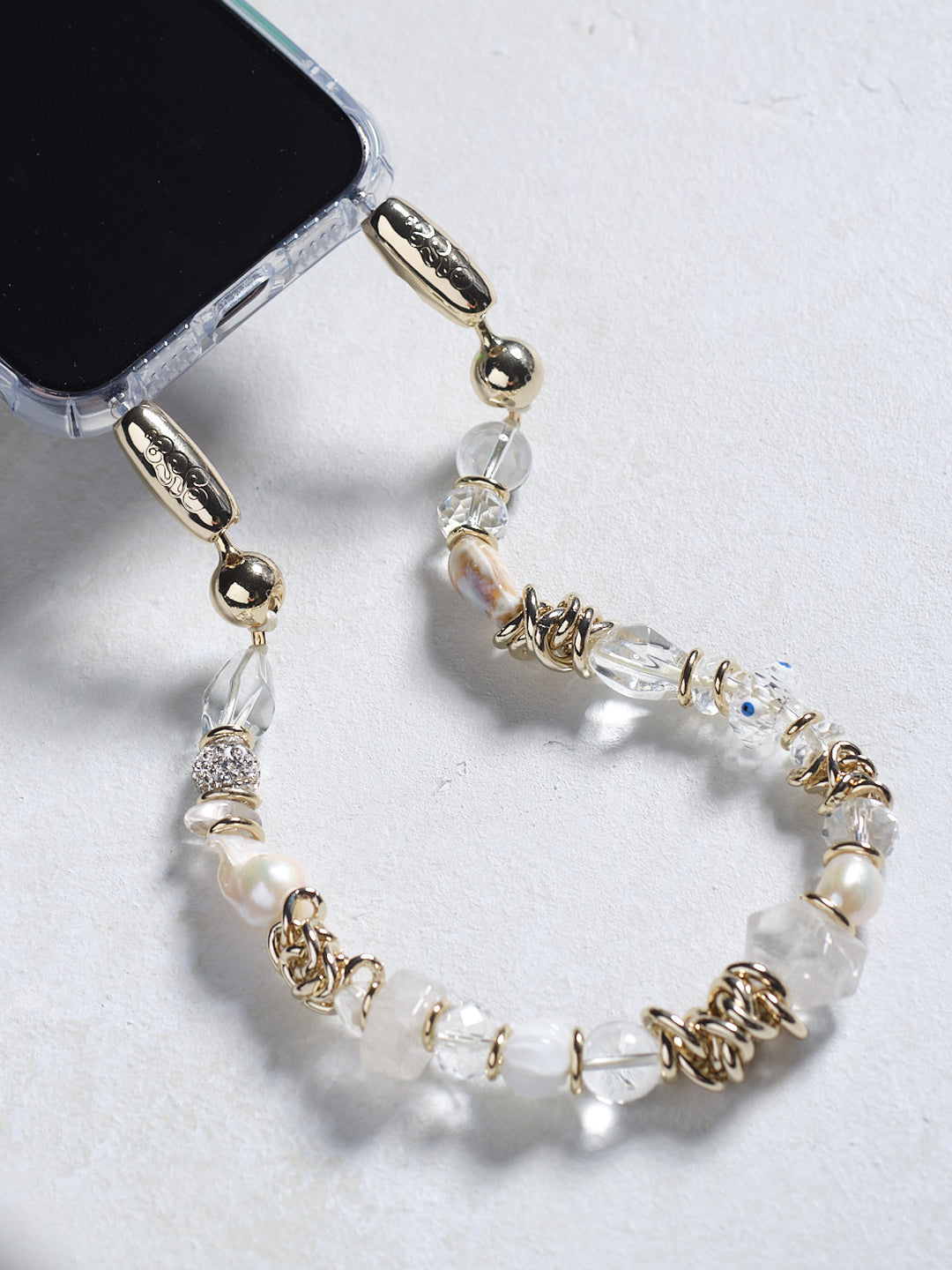 Gemstone and motif beads strung together with chain link details to create the Ossa Crystal Et Cetera Wristlet Phone Accessory at Alas Eius.