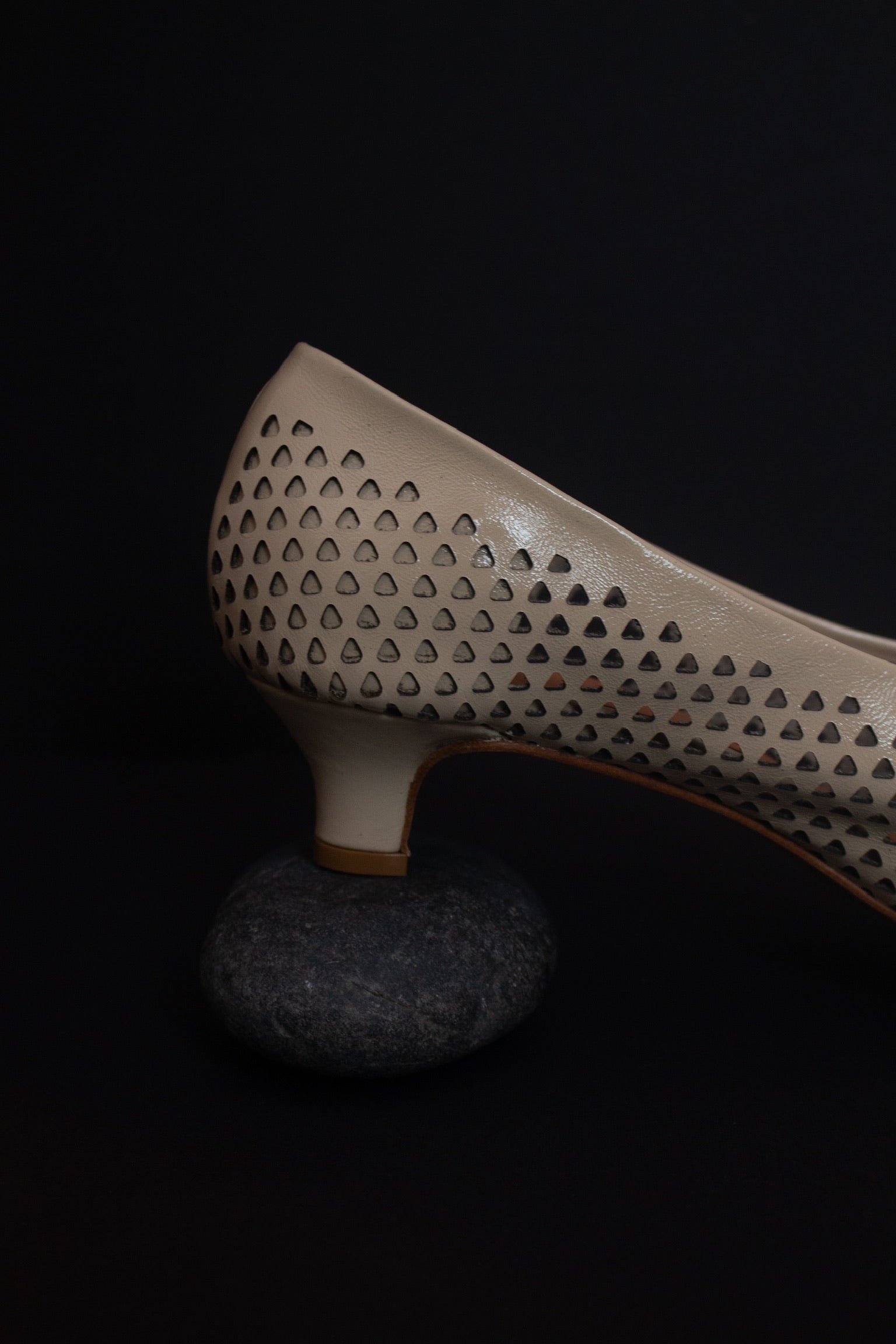 Side view of the chic and sophisticated Rachel Comey Champagne Clemmie Kitten Heel featuring a pointed-toe with a perforated triangular design on crinkle patent leather at an Alas Eius store.