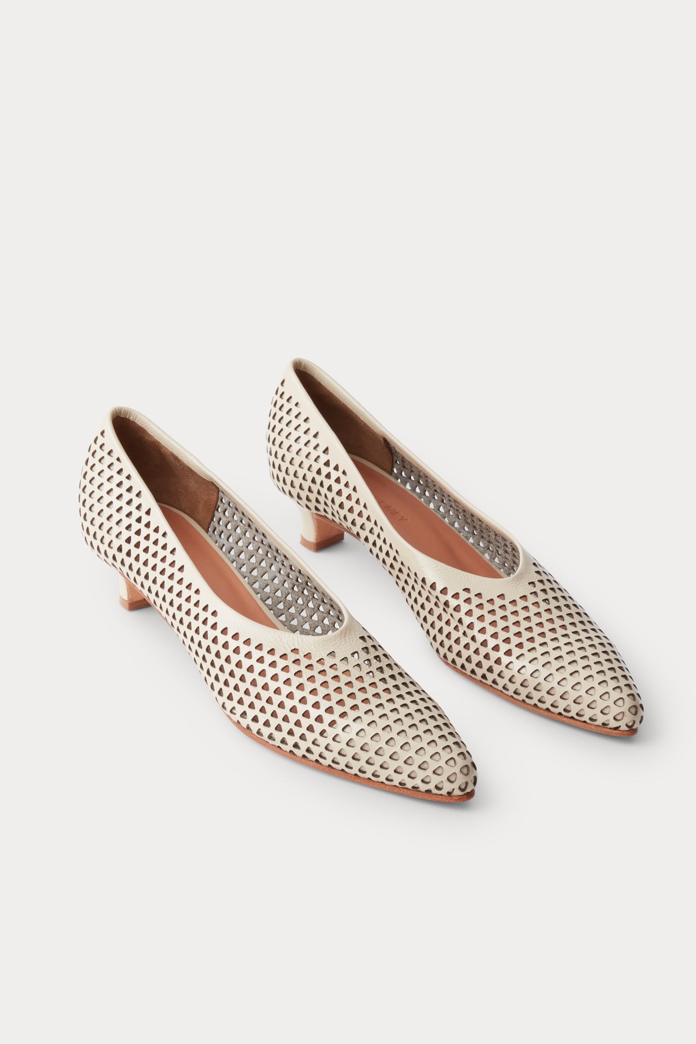 Top view of the chic and sophisticated Rachel Comey Champagne Clemmie Kitten Heel featuring a pointed-toe with a perforated triangular design on crinkle patent leather at an Alas Eius store.