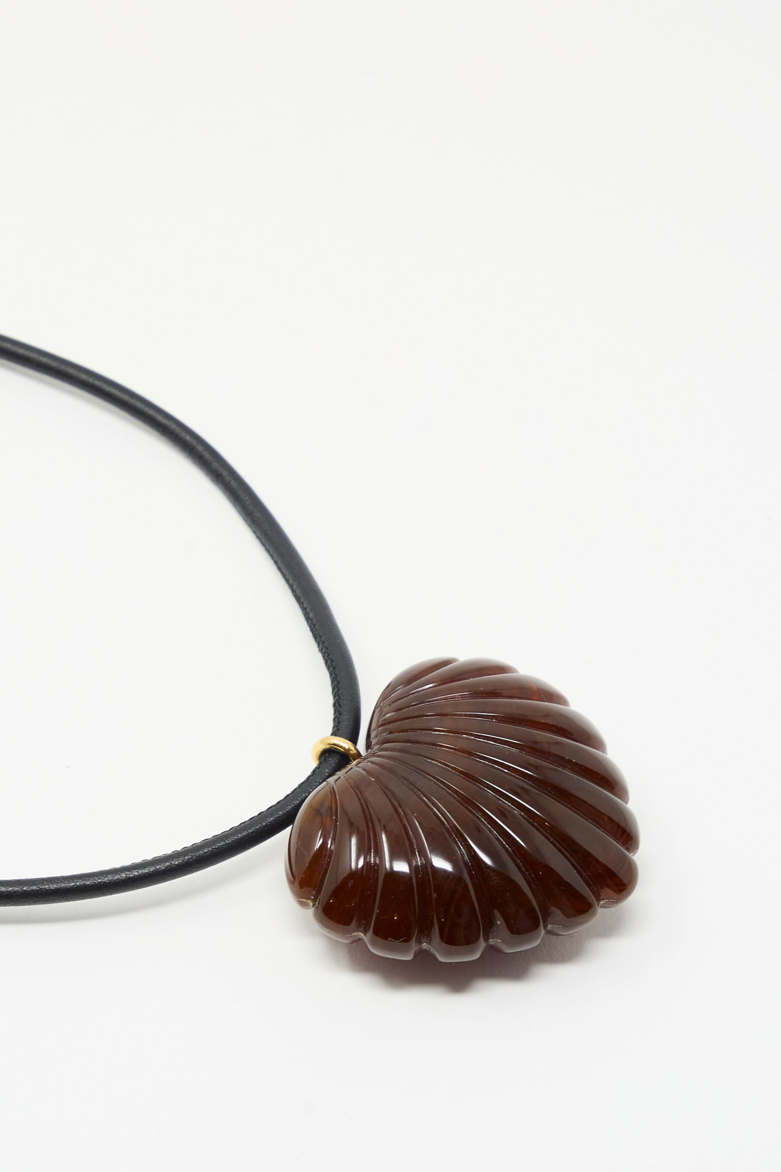 Rachel Comey Dark Tortoise Findon Necklace featuring a sculptural, shell-inspired heart pendant in acrylic, suspended on slim leather cording at an Alas Eius store. 