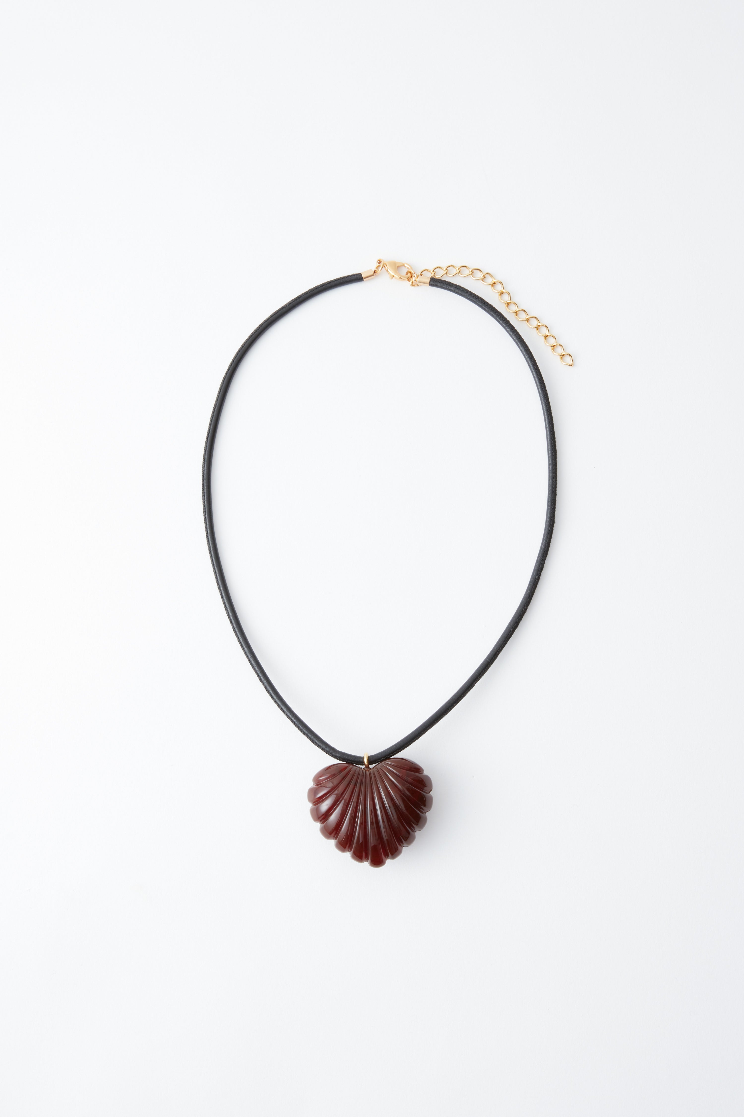 Rachel Comey Dark Tortoise Findon Necklace featuring a sculptural, shell-inspired heart pendant in acrylic, suspended on slim leather cording at an Alas Eius store. 