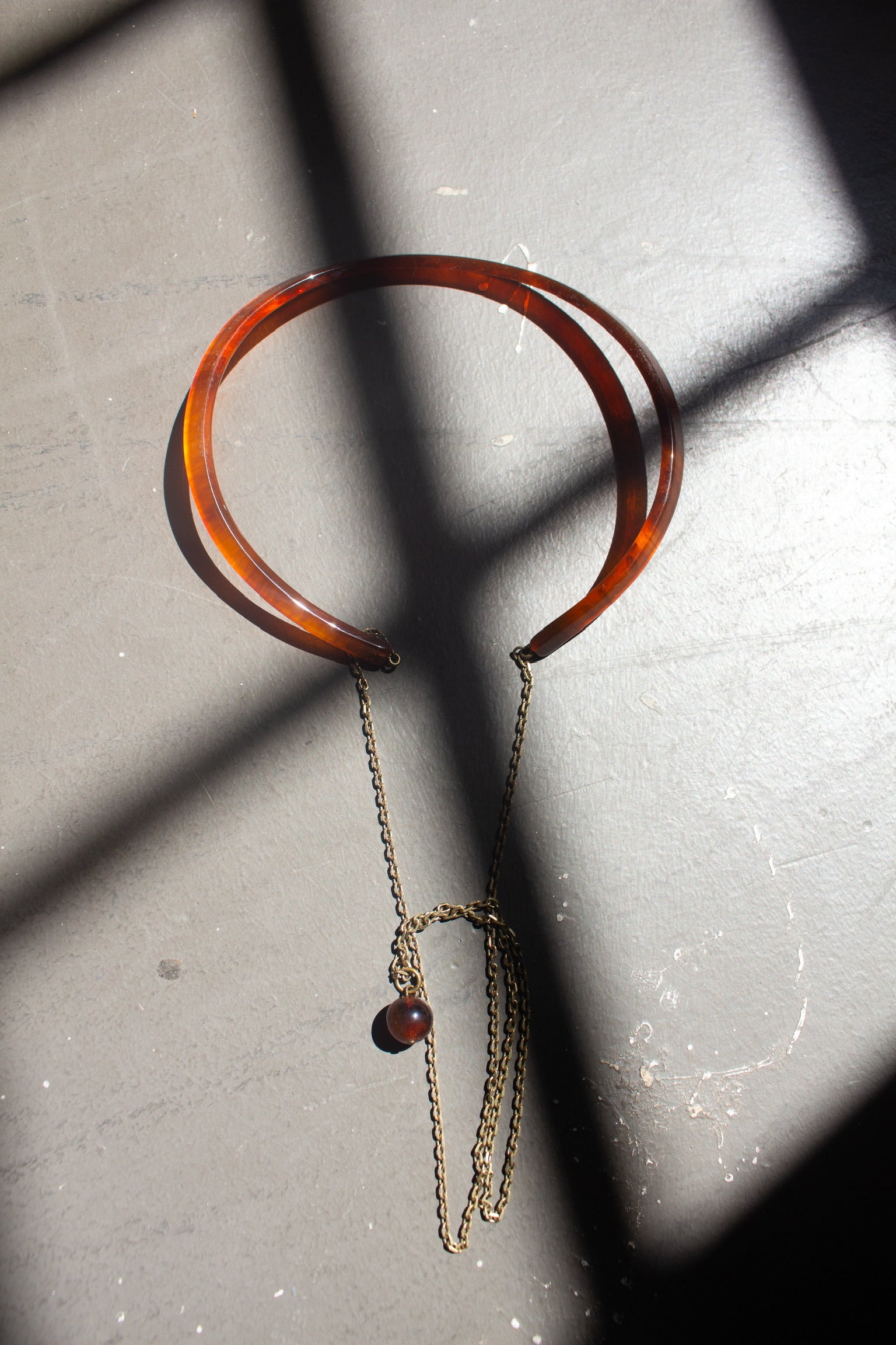 Rachel Comey Dark Tortoise Priori  Semi-Rigid Choker with Chain crafted from matte acrylic with an open back. Suspended from each end of the collar is a delicate brass chain that falls at the back, finished with a single bead accent at an Alas Eius store. 