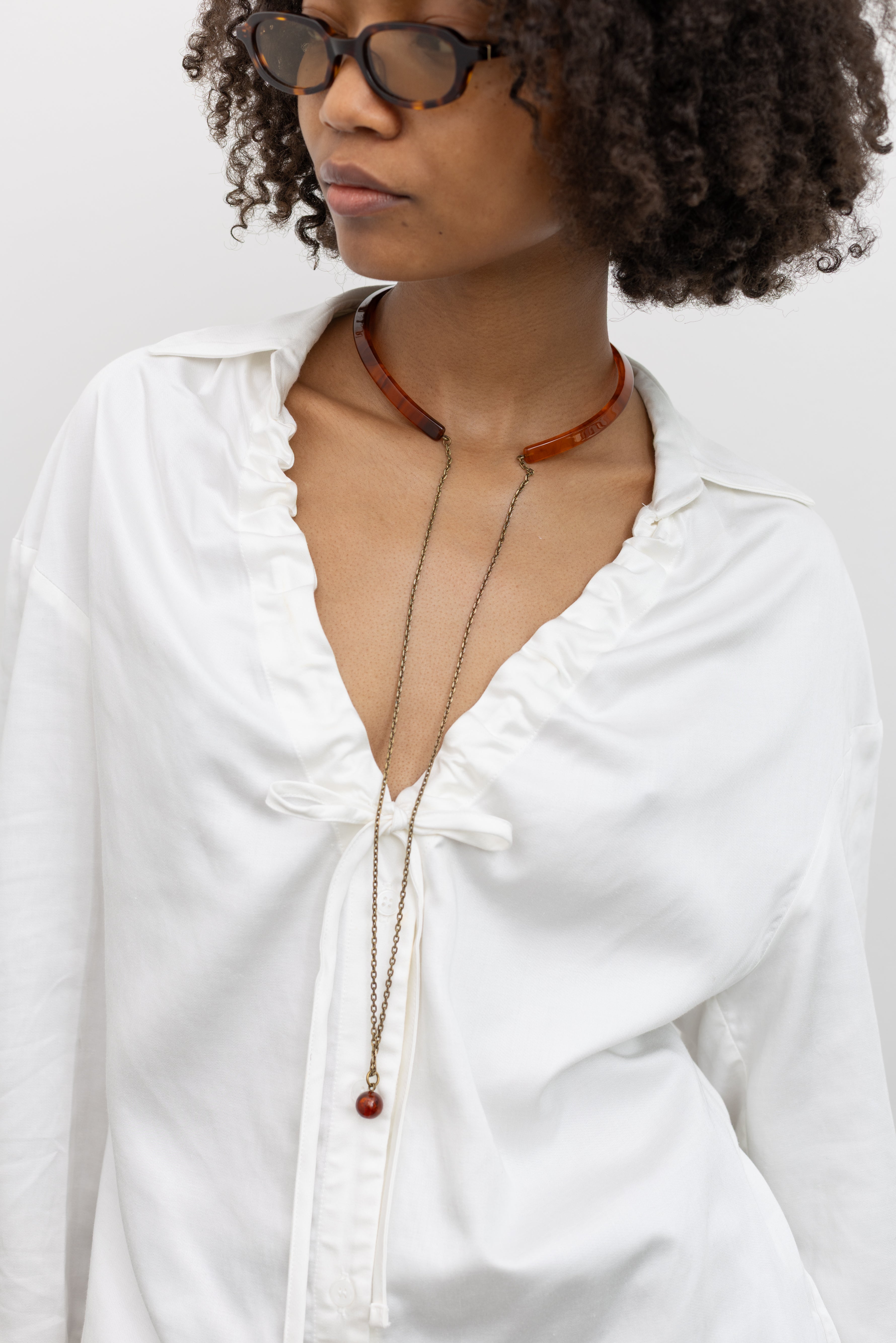 Rachel Comey Semi-rigid matte acrylic choker with an open back and delicate brass chain detail at the nape at Alas Eius. 