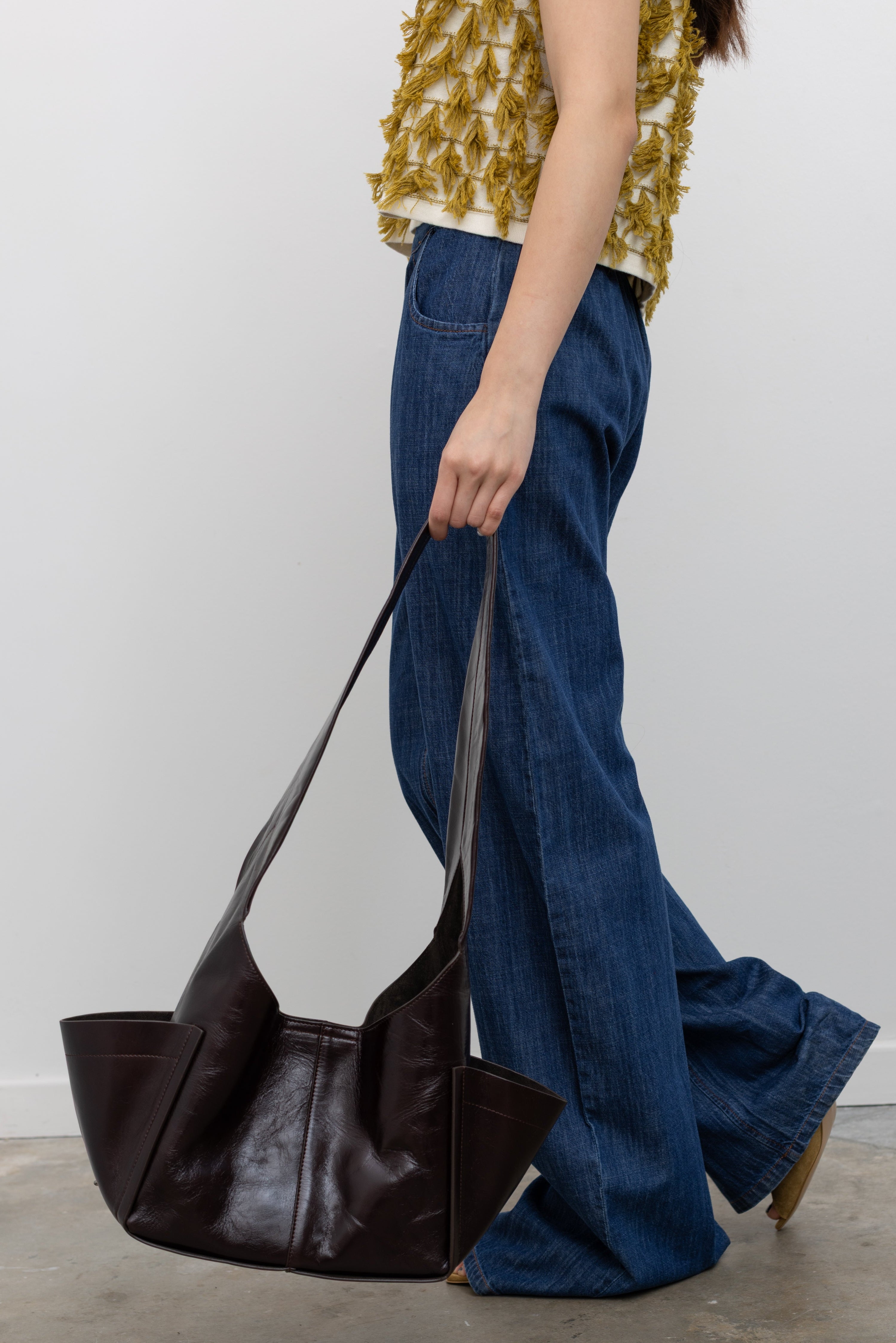 Rachel Comey minimal everyday bag featuring extended outer pockets and a clean magnetic fastening with versatile carry options at Alas Eius. 