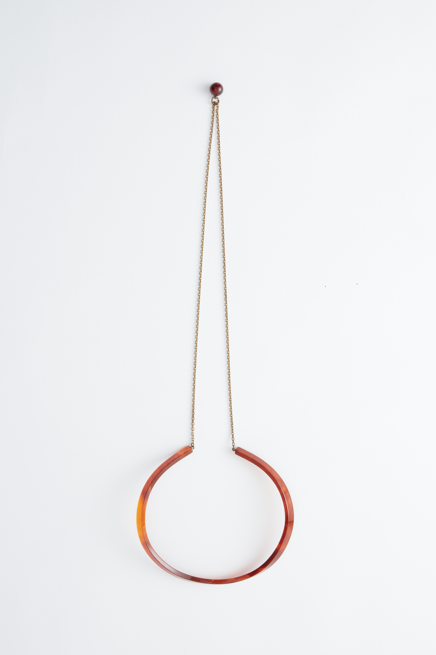 Product view of the modern Rachel Comey Dark Tortoise Priori  Semi-Rigid Choker with Chain crafted from matte acrylic with an open back. Suspended from each end of the collar is a delicate brass chain that falls at the back, finished with a single bead accent at an Alas Eius store. 