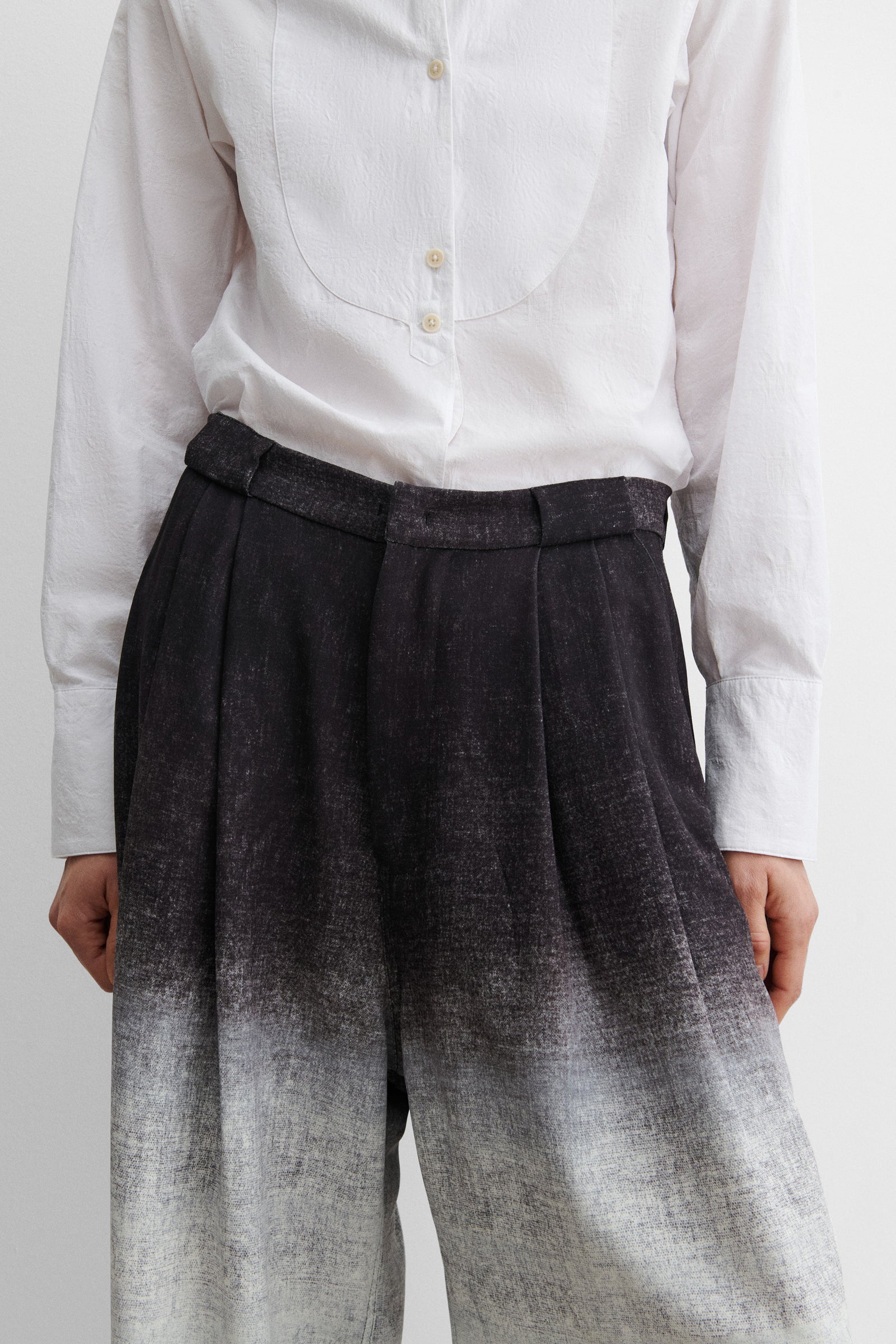 Close-up front view of Rachel Comey minimal tailored wide-leg trousers with front pleats, belt loops, and functional pocket design at Alas Eius.