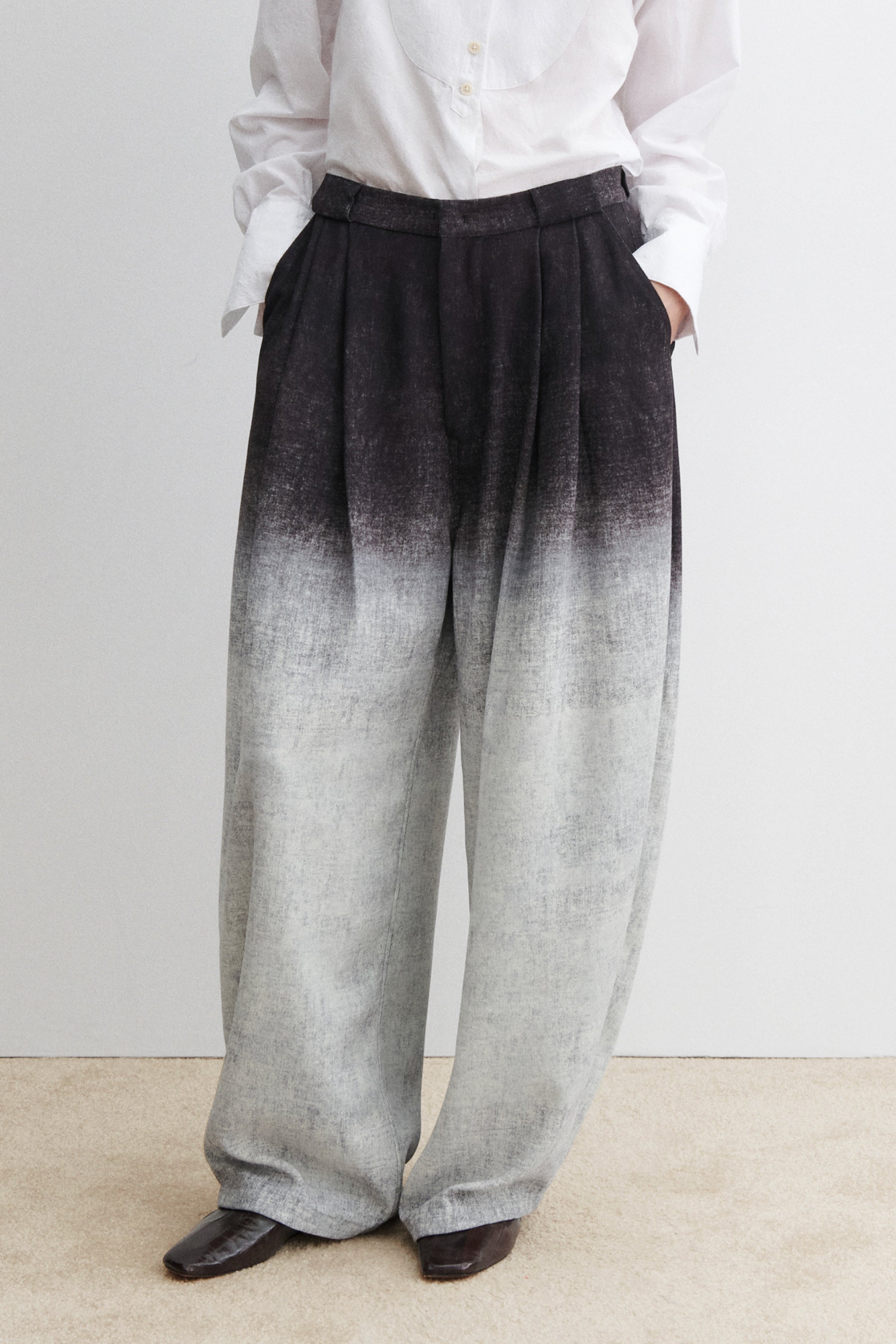 Rachel Comey high-waisted wide-leg trousers in softly textured fabric with front pleats, belt loops, slanted side pockets, and rear patch pockets, finished with a concealed front closure and relaxed drape at Alas Eius.