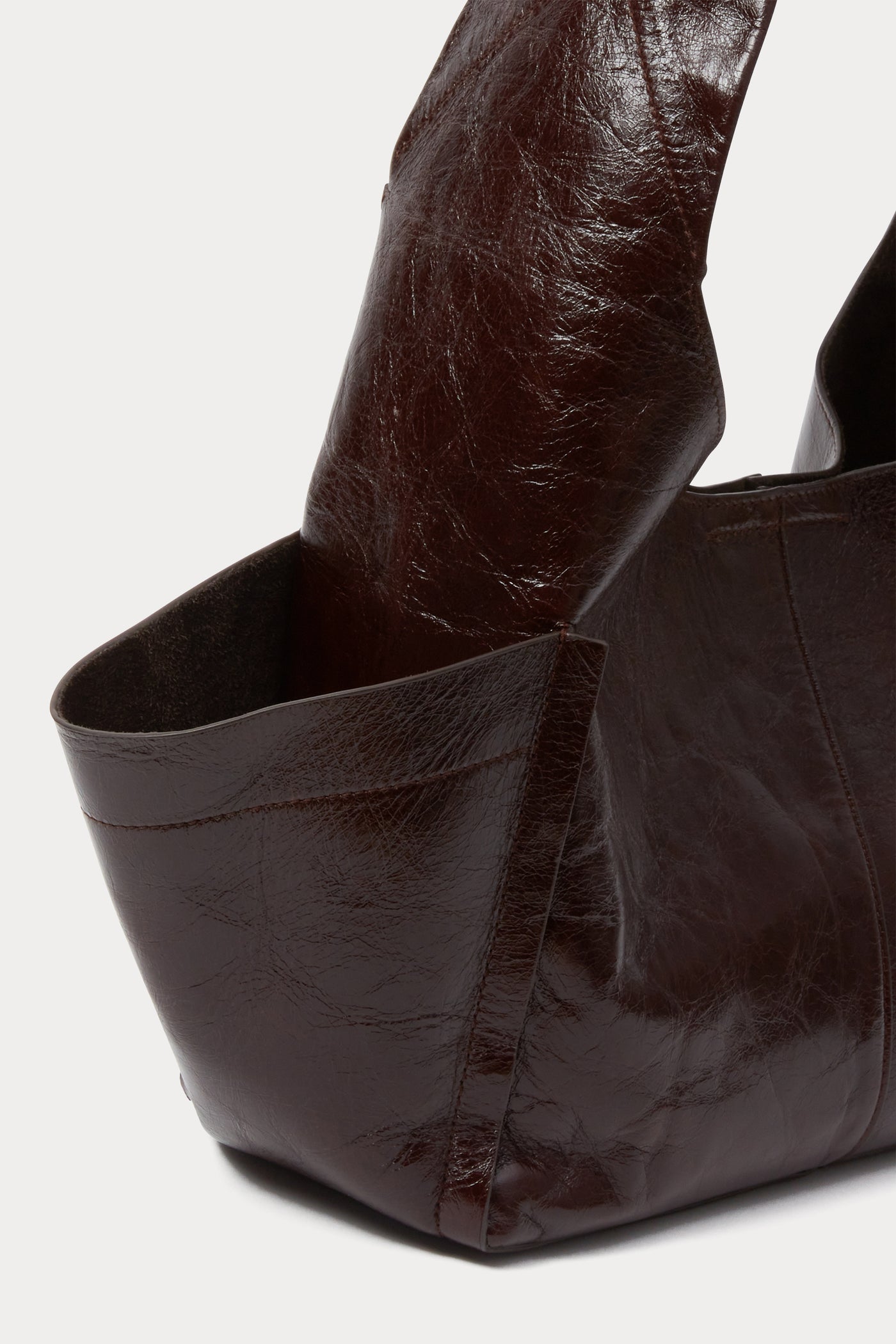 Close-up view of the outside pocket on the versatile Rachel Comey Chestnut Leather Tool Bag featuring a fixed shoulder strap, extended exterior pockets, and magnetic closure. Can be worn over the shoulder or across the body at an Alas Eius store. Made in Italy. 