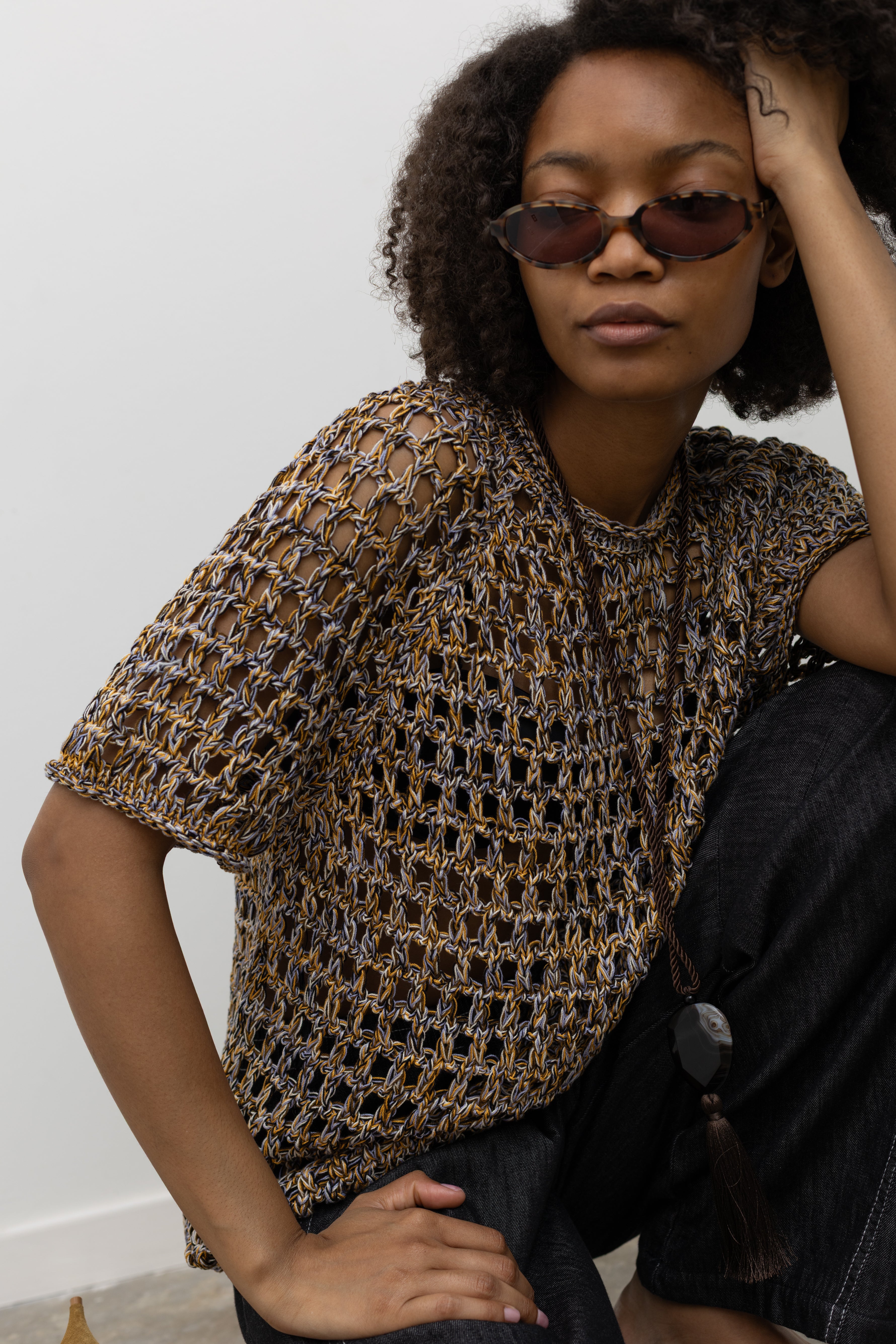 Model wearing Rachel Comey airy open-knit cotton top with a colorful woven design, relaxed fit, and rolled neckline detail at Alas Eius