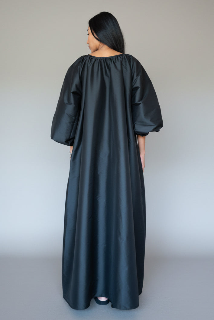 Sloan black Minimal Maxi Dress with sculptural sleeves and floor-length silhouette at Alas Eius