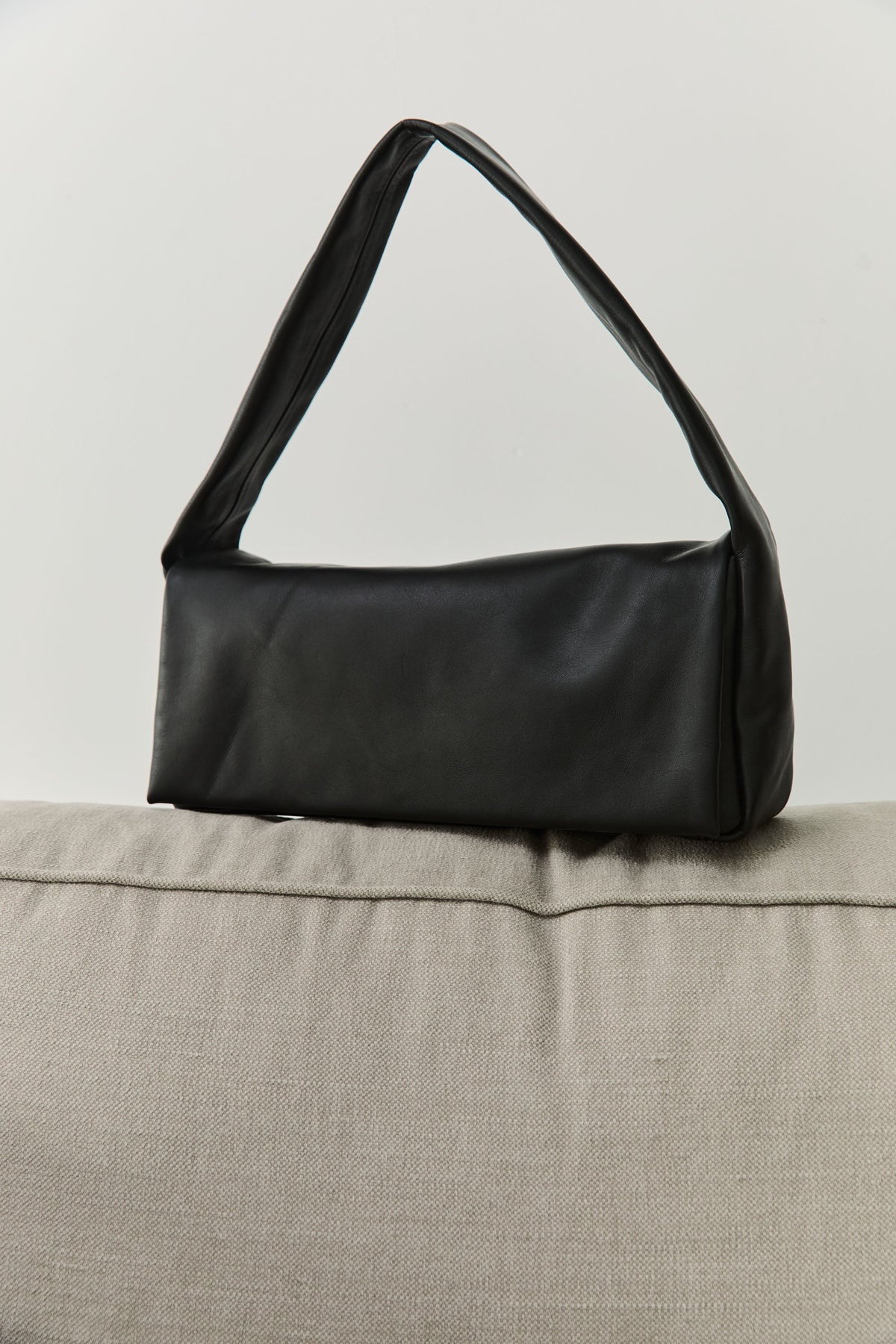 A St. Agni black leather soft slim satchel bag which is lined with cotton canvas and features a magnetic closure at Alas Eius.