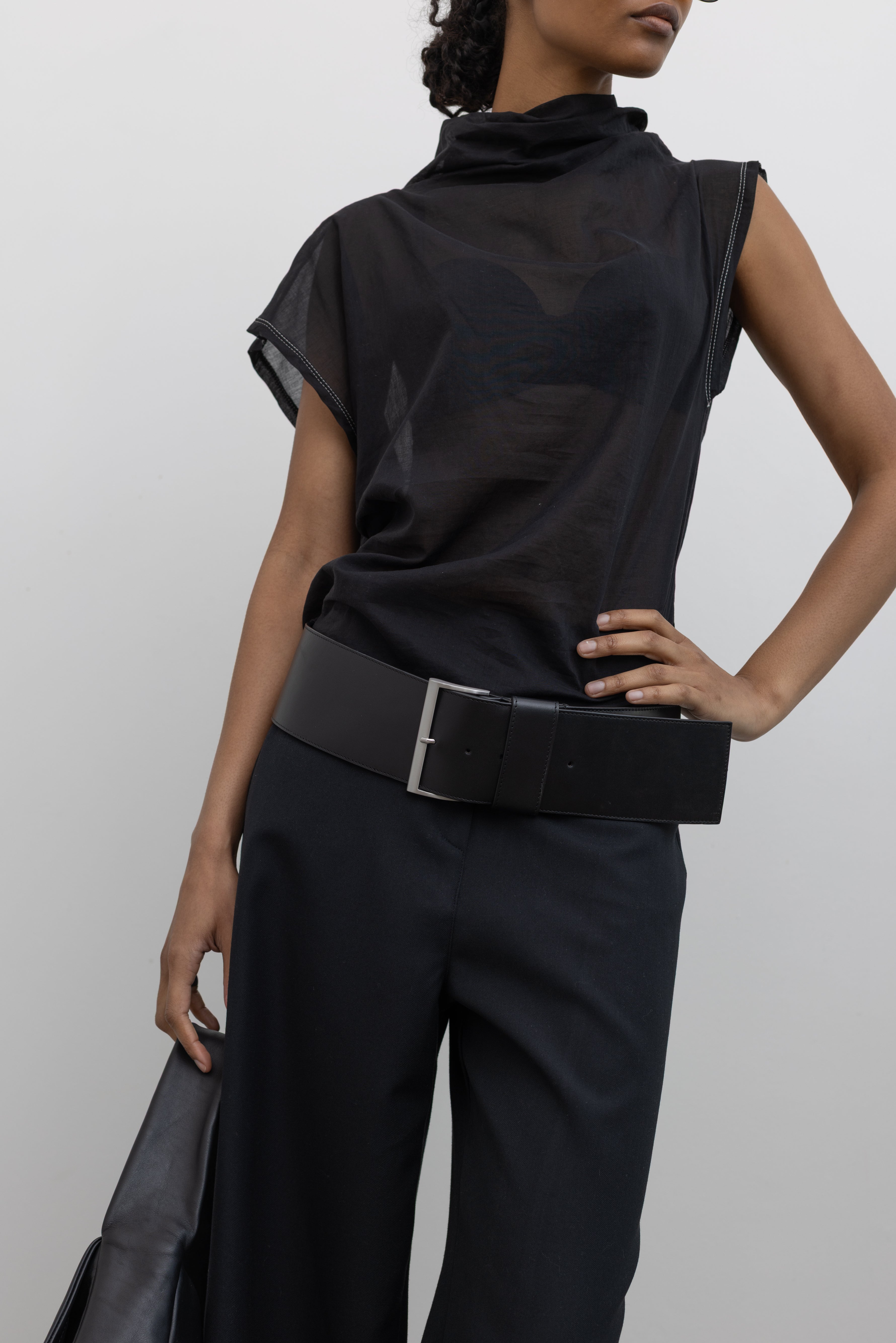 Woman wearing a sleek and sophisticated St. Agni Black Leather Wide Classic Belt with a brushed silver rectangular buckle at Alas Eius.