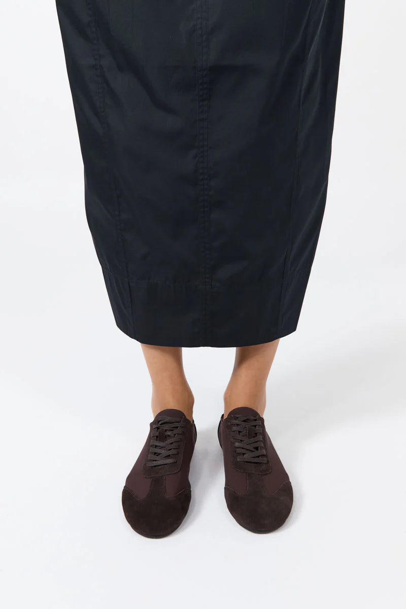 Front view of a woman wearing a feminine and minimalist design St. Agni brown ballet lace up sneaker at Alas Eius. 