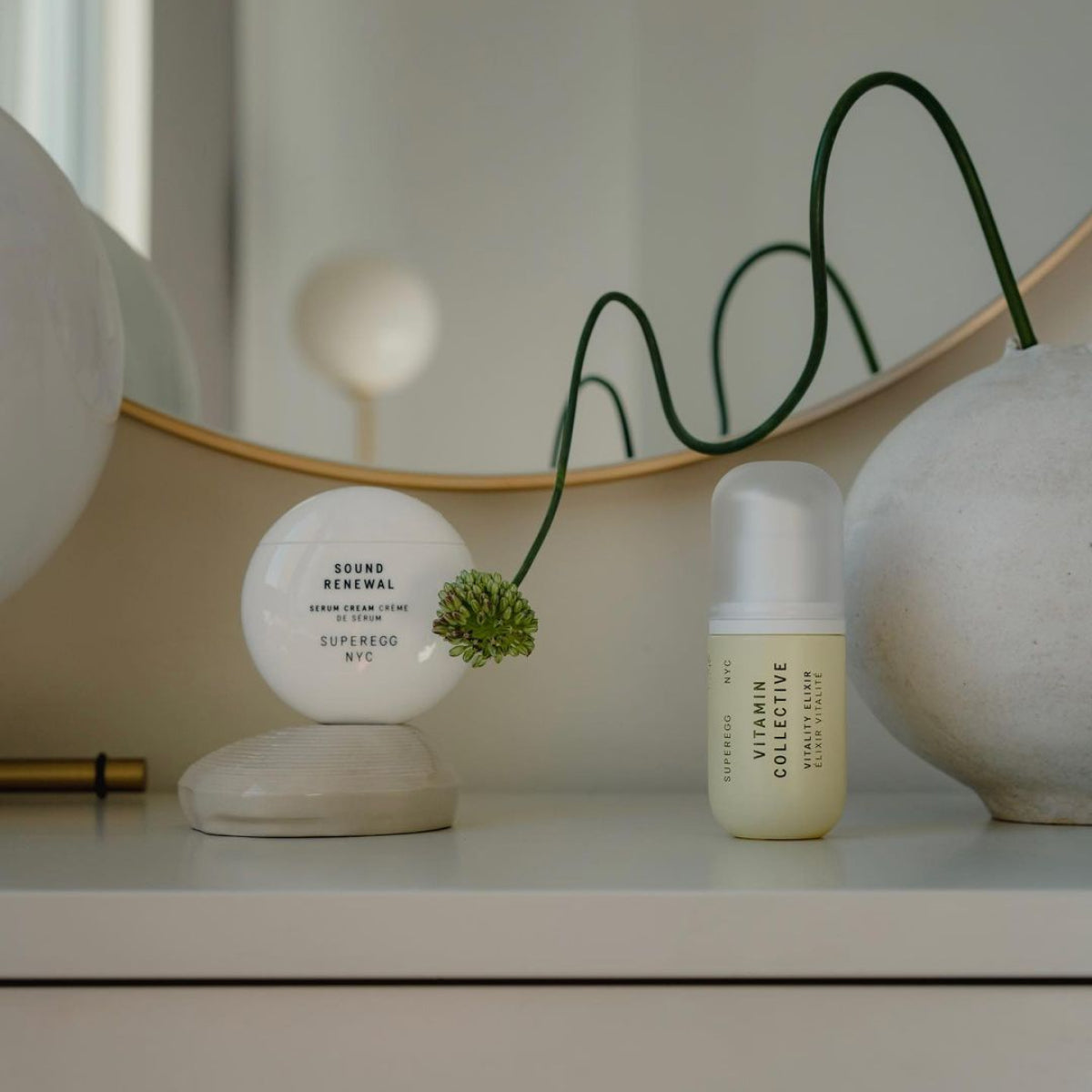 Small bottle of Superegg Skincare Vitamin Collective Vitality Elixir on a dresser. The serum features a brightening treatment developed with a precisely dosed, concentrated collective of vitamins (B, C, E, F, K) and botanicals to bring rich antioxidant energy to the skin at Alas Eius.