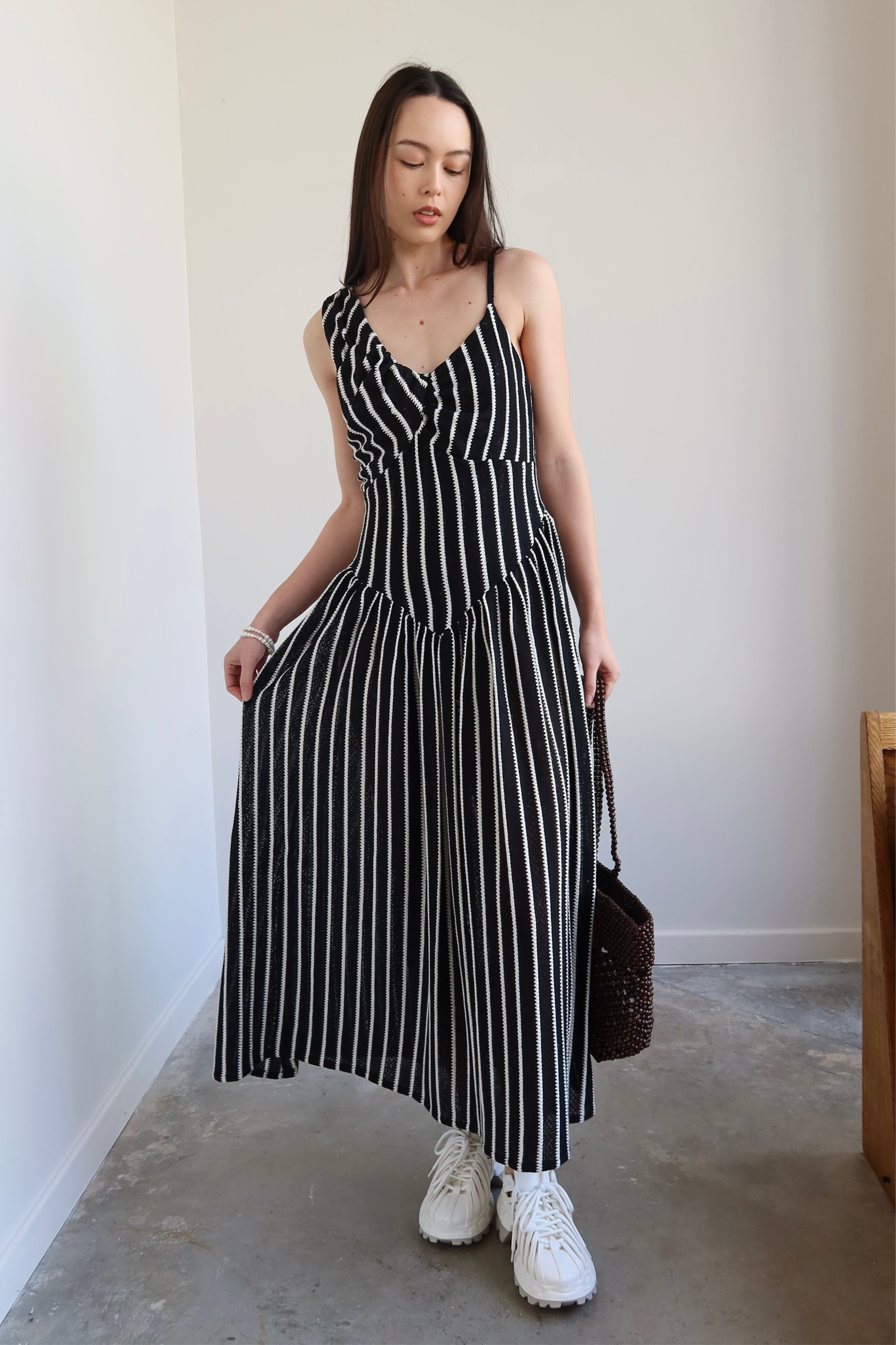 Full length front view of a woman wearing Tach Ikia Black Striped Knitted Maxi Dress at Alas Eius