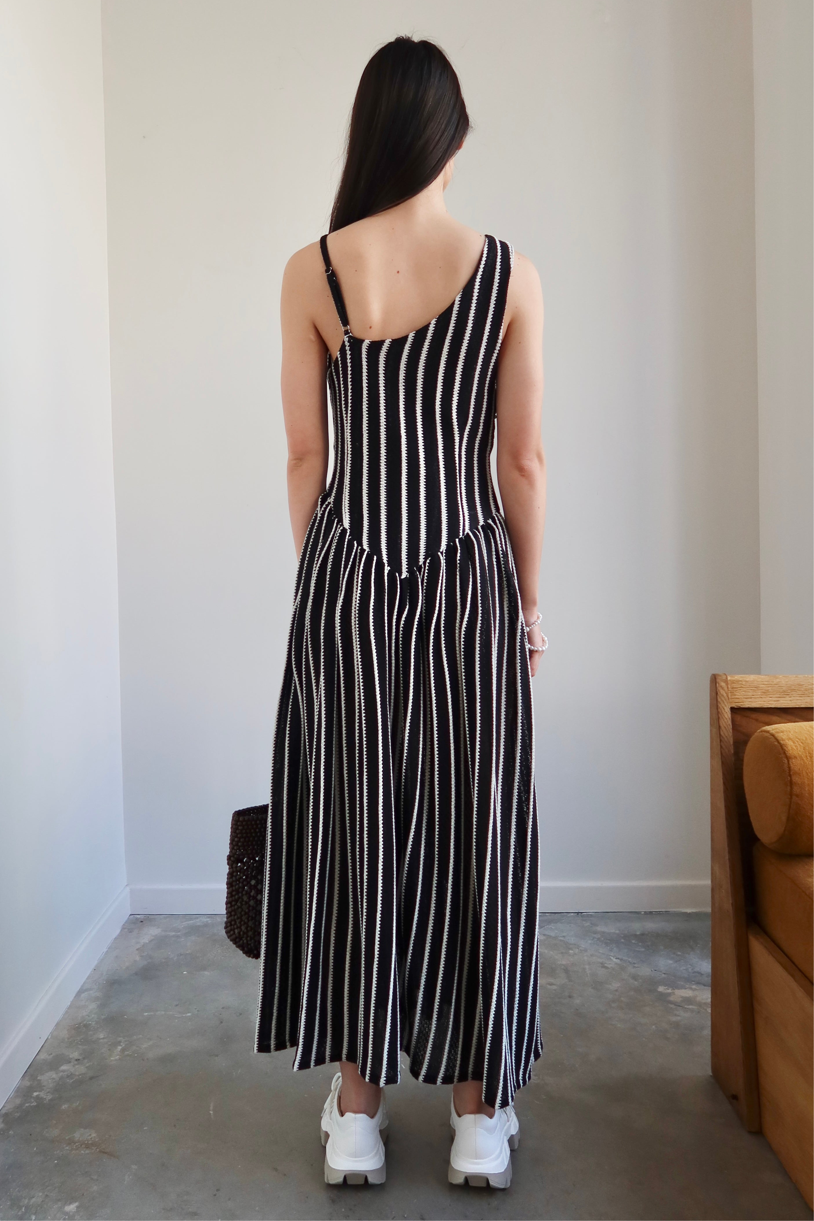 Full length front view of a woman wearing Tach Ikia Black Striped Knitted Maxi Dress at Alas Eius