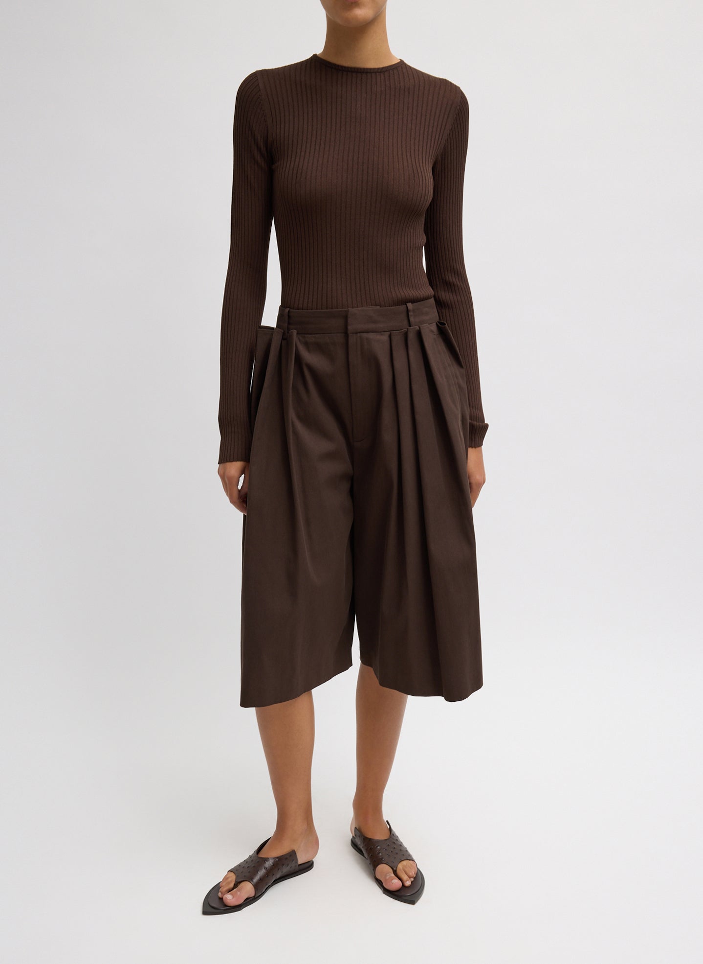 Woman wearing Spring fashion in a brown ribbed sweater and Tibi Brown Luxe Spring Twill Tucked Pleated Wide Leg Short at Alas Eius