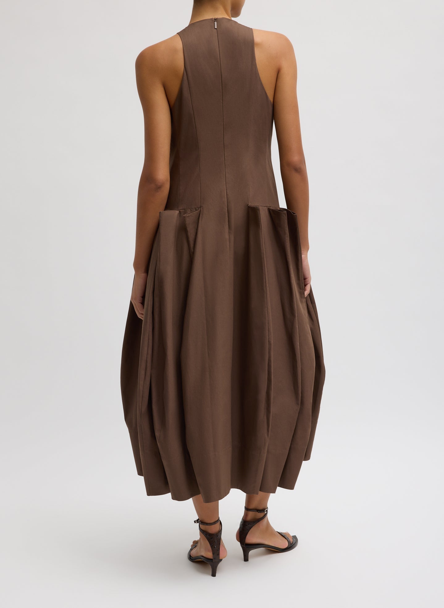 Back view of a woman wearing Spring fashion in a Tibi Brown Compact Eco Poplin Pinched Pleat Dress with zipper at Alas Eius