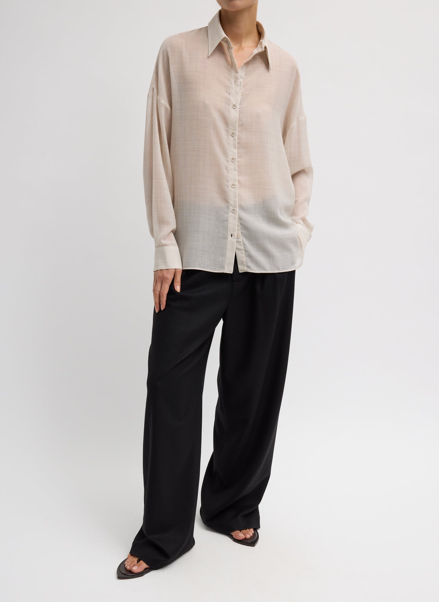 Woman wearing Spring fashion in black trousers and a Tibi Oatmeal Sheer Wool Gauze Oversized Shirt at Alas Eius