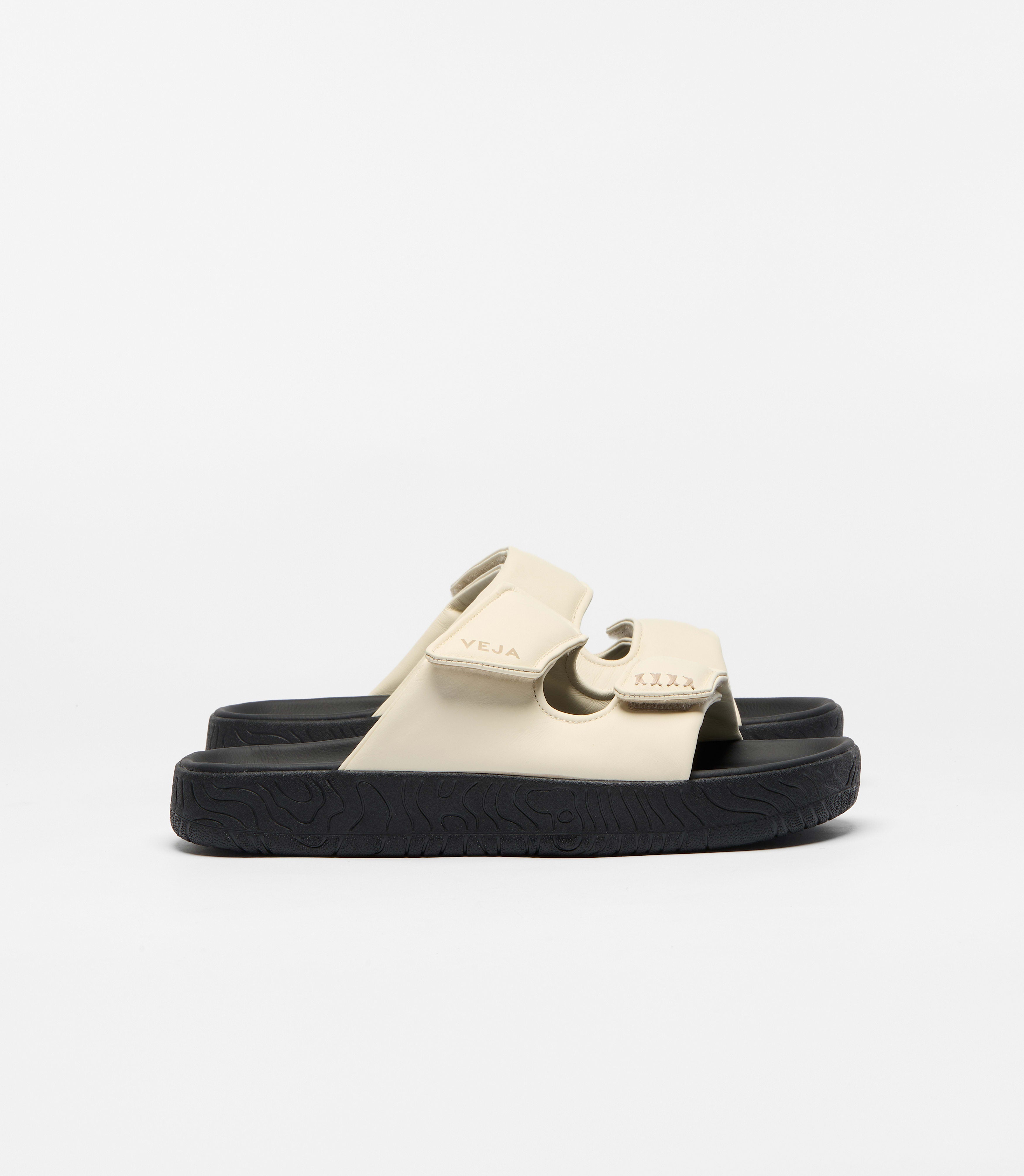 Veja sandal featuring a minimalist double-strap silhouette crafted in a soft cream leather and a bold black platform sole at an Alas Eius store. 