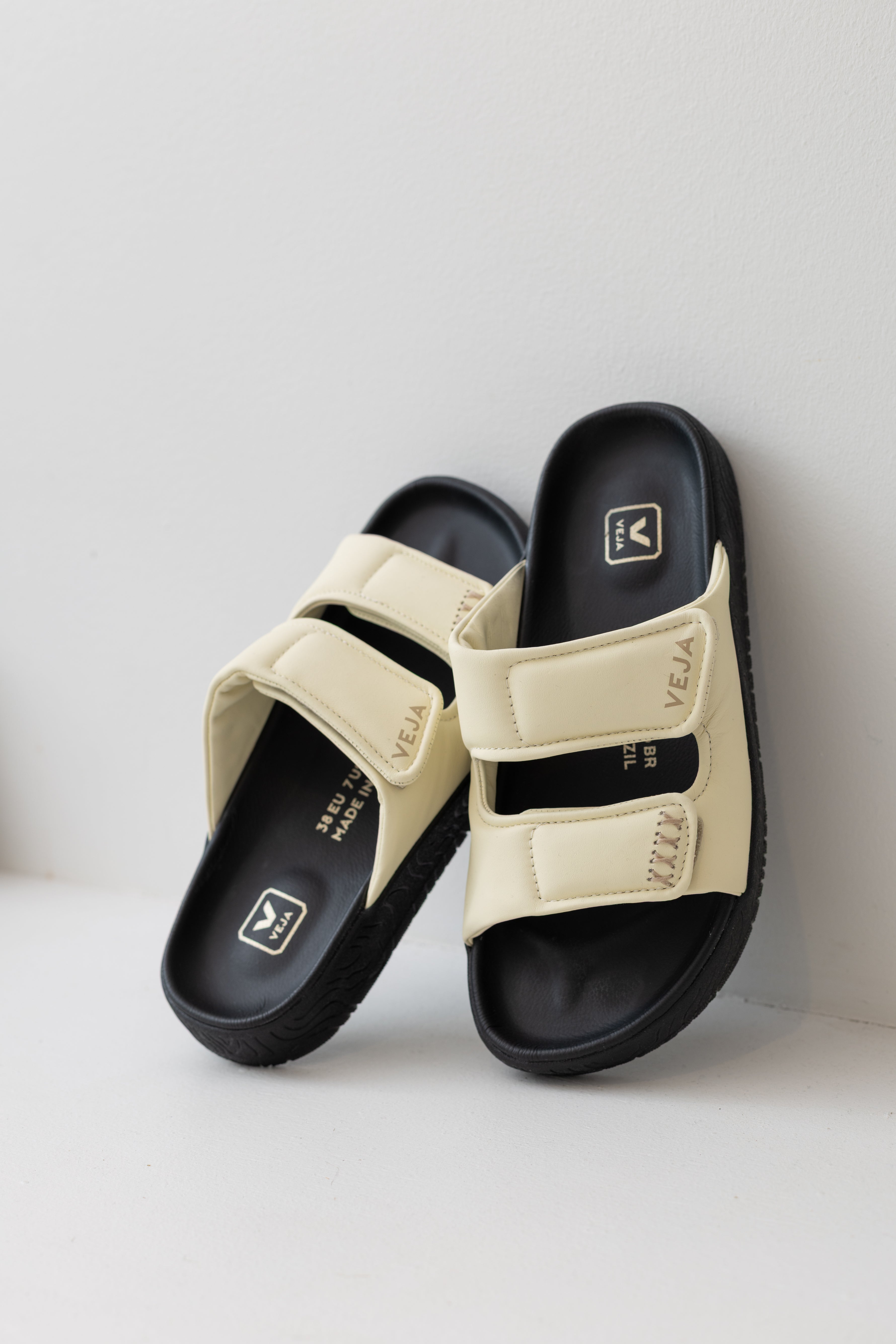 Veja sneaker brand cashew off white leather etna bold double strap slide sandal with black platform sole at Alas Eius. 