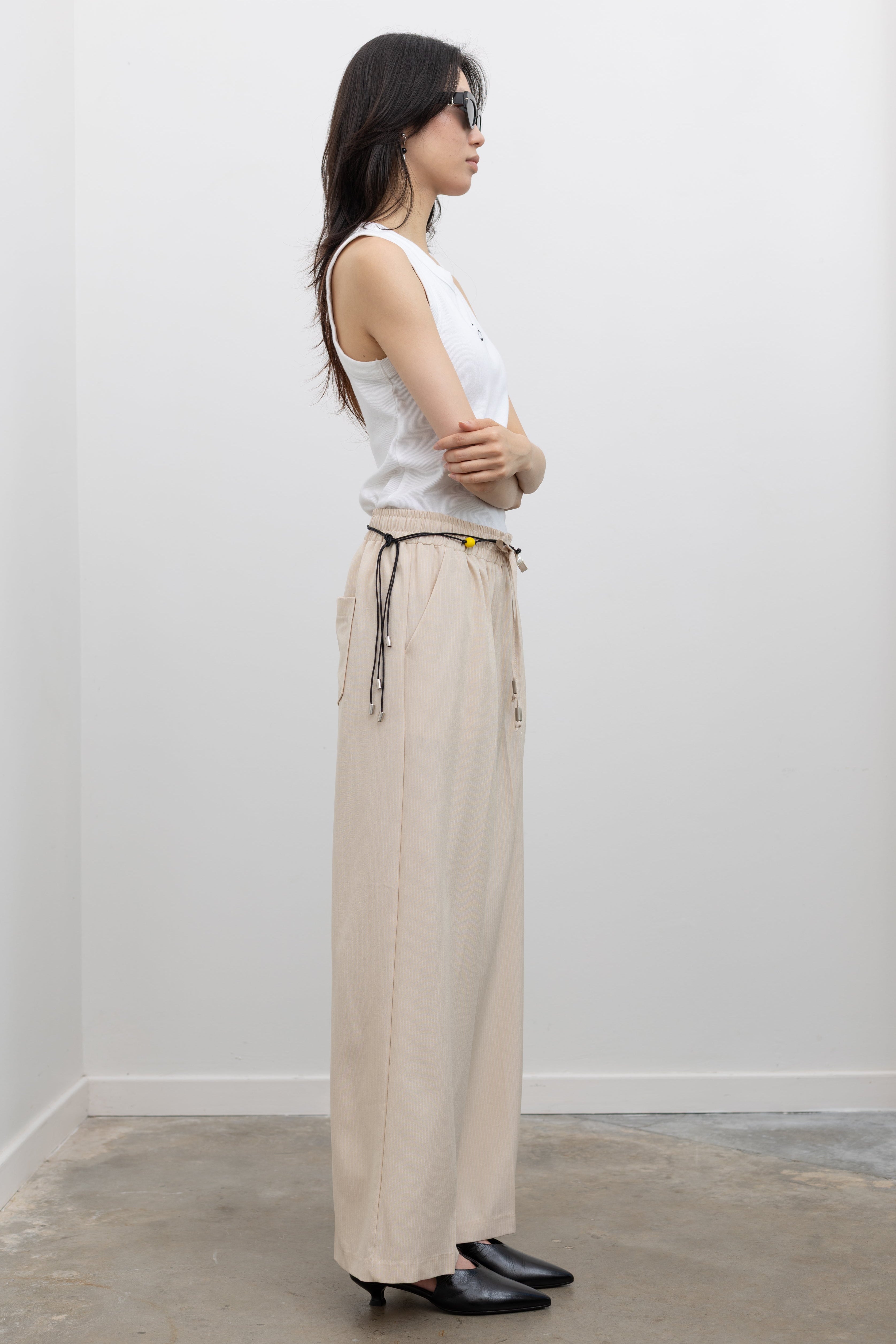 Collective elasticated waist pinstripe trousers with drawstring detail and fluid silhouette, designed for women's capsule wardrobe essentials at Alas Eius