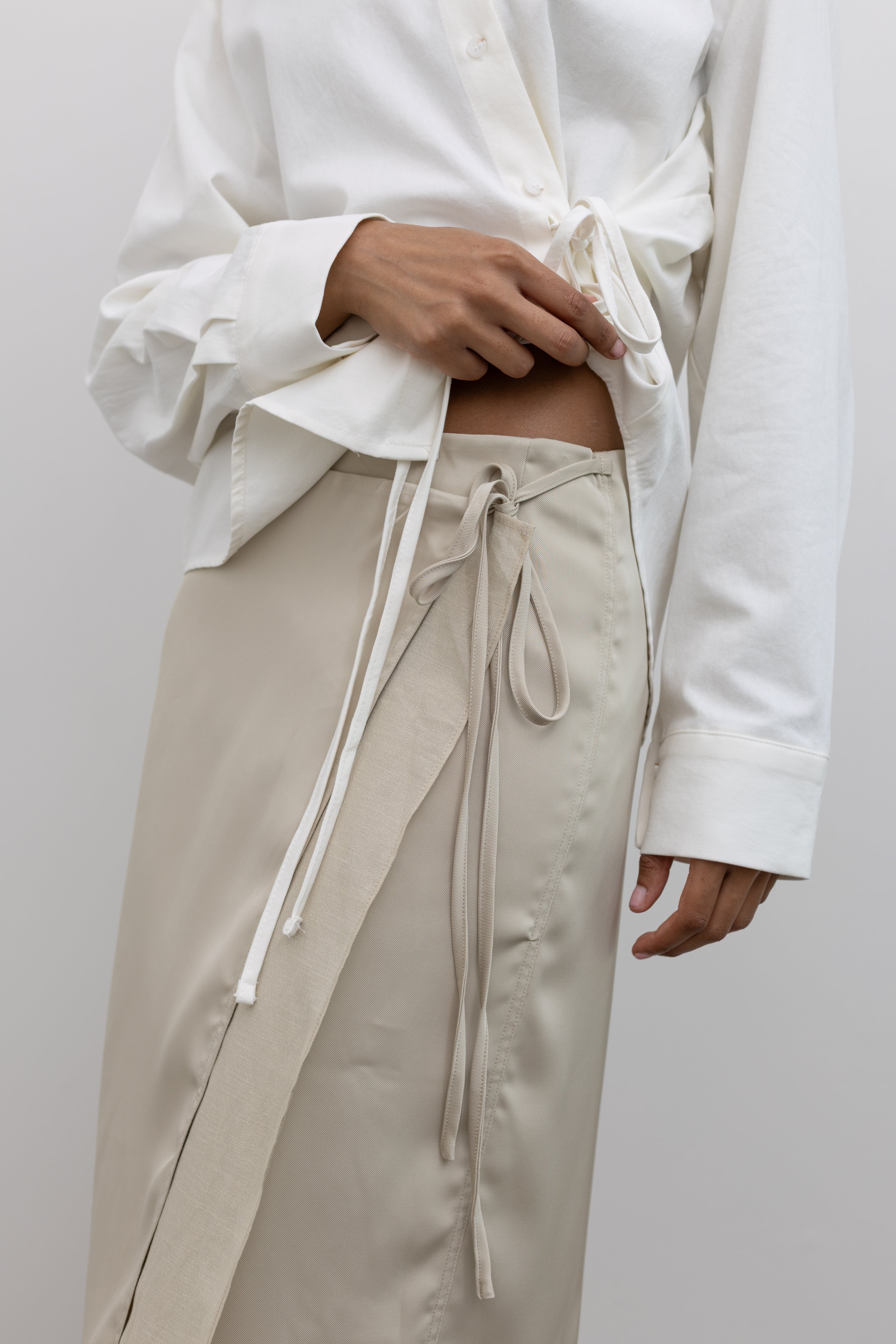 Alas Eius Elegant Beige Satin Wrap Skirt with Soft Tie Waist and Midi Silhouette at Alas Eius