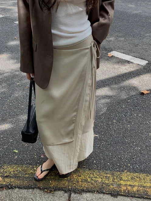 Beige satin wrap midi skirt with adjustable button closure and tie waist detail, elegant women's fashion at Alas Eius