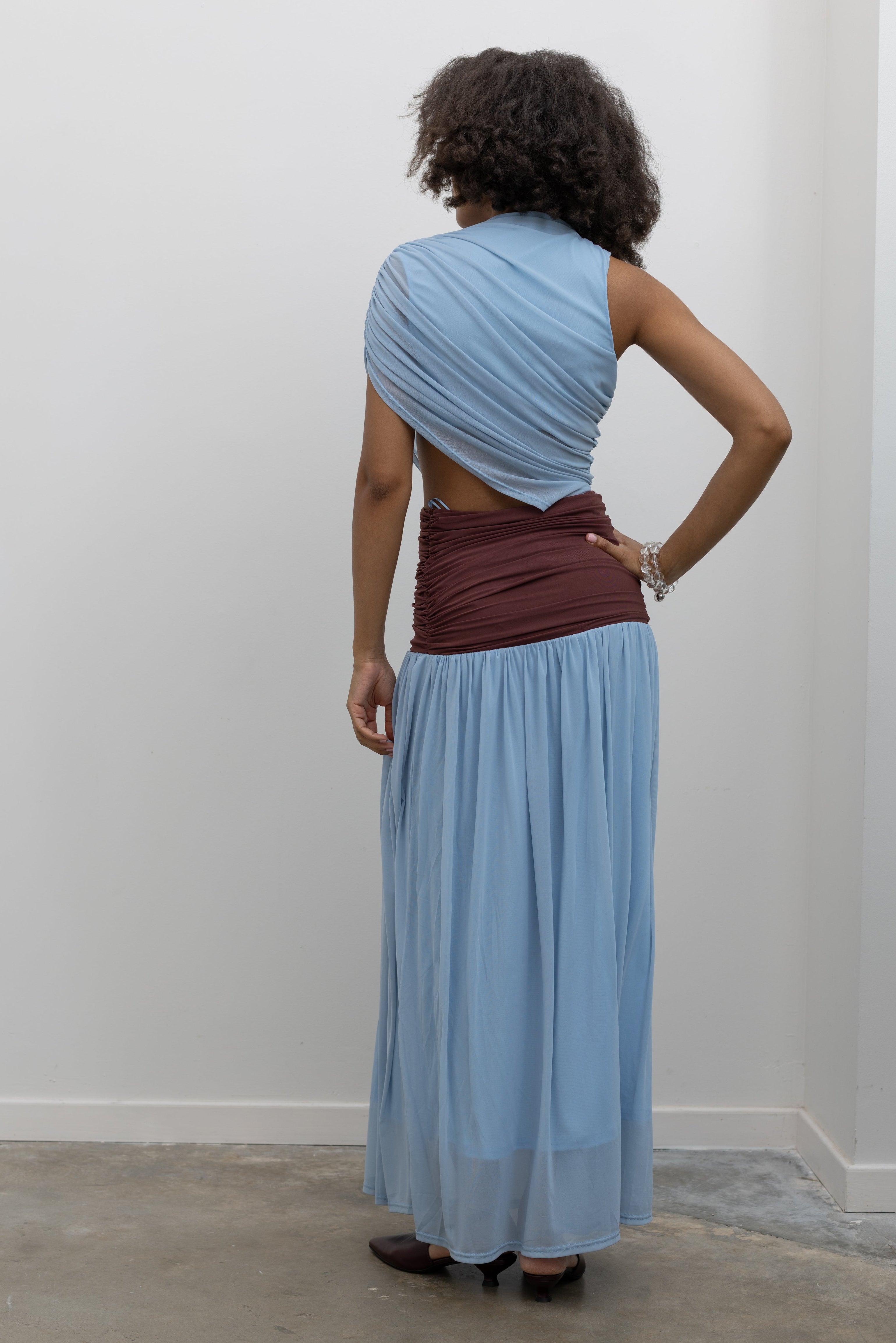 Collective sleeveless stretch-mesh maxi dress with an asymmetric powder-blue bodice, sculptural ruched waistband, and flowing pleated skirt at Alas Eius