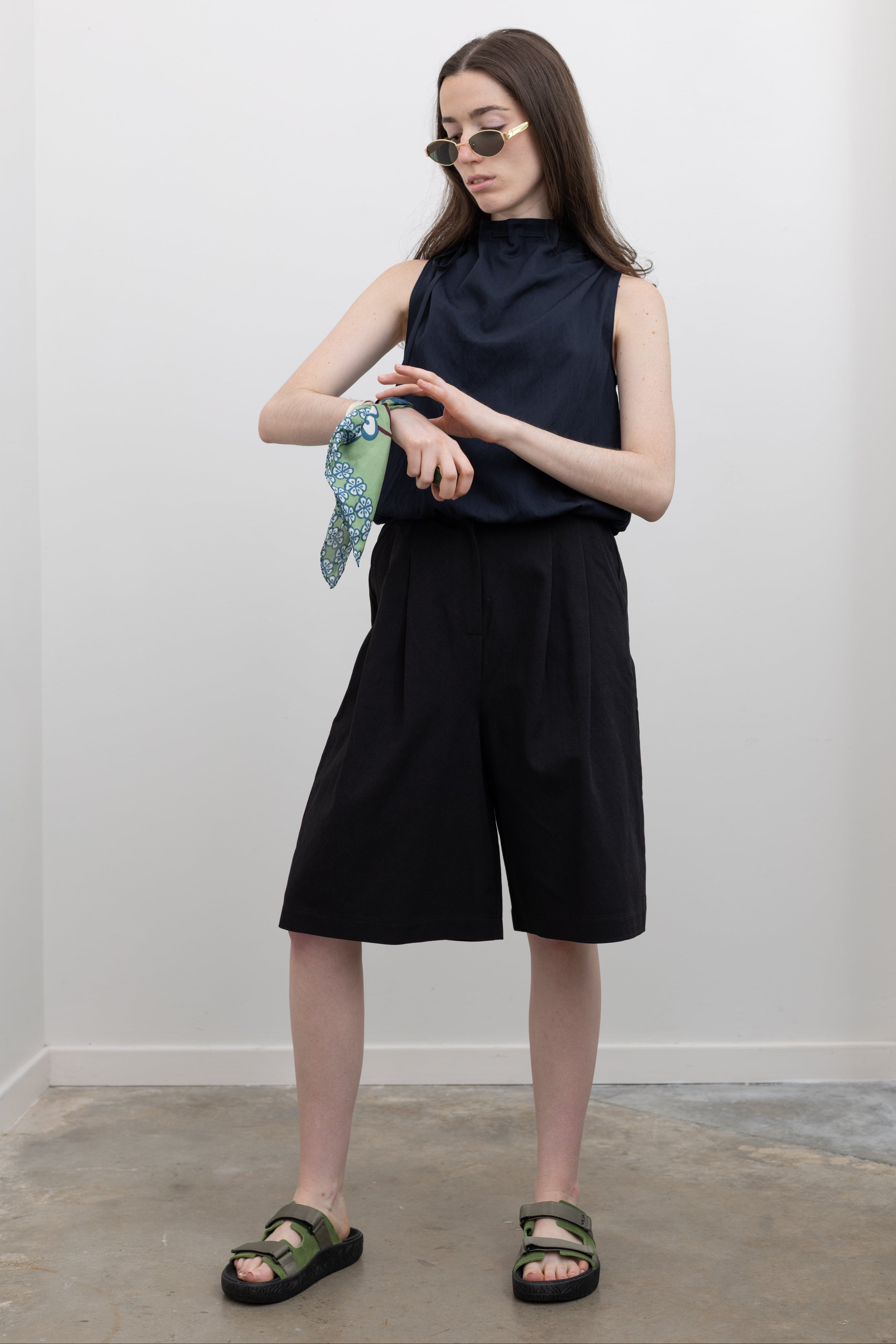 Collective black dress shorts featuring a zip and button closure, side pockets, and a versatile bermuda silhouette at Alas Eius.