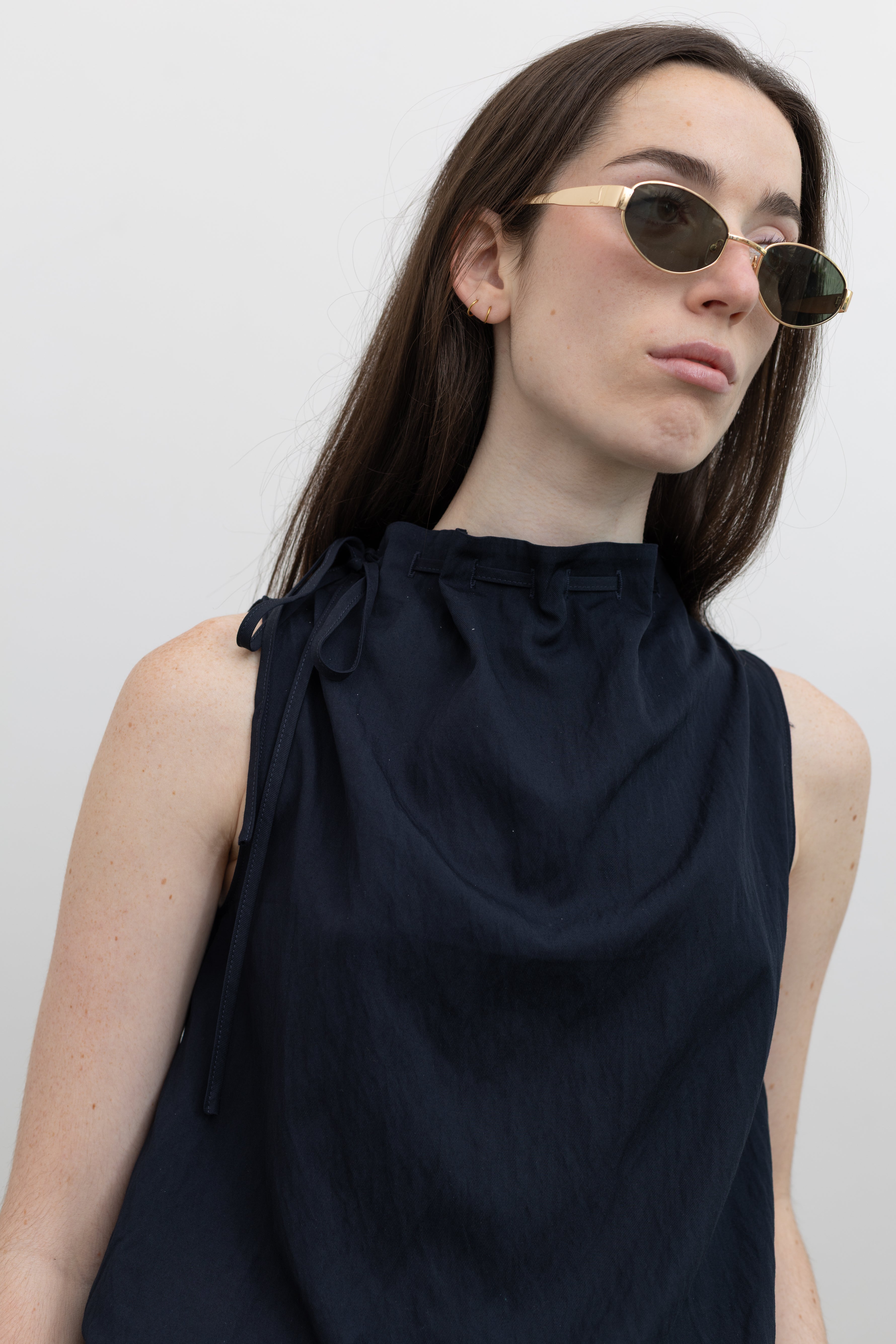 Collective black mock neck tank top featuring adjustable tie neckline and sculptural bubble hem silhouette at Alas Eius.